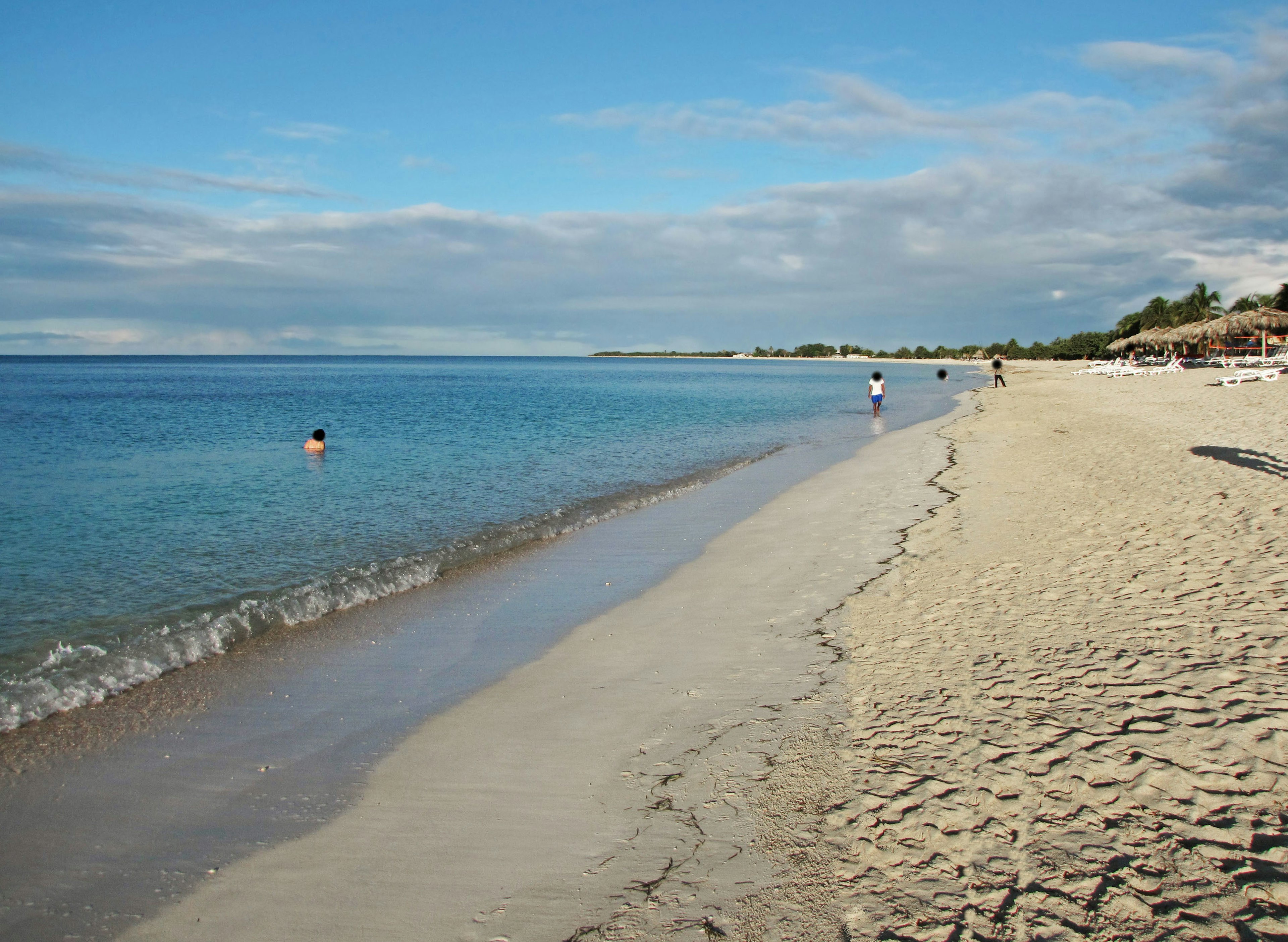 Malersicher Strand mit blauem Ozean und weißem Sand mit Menschen