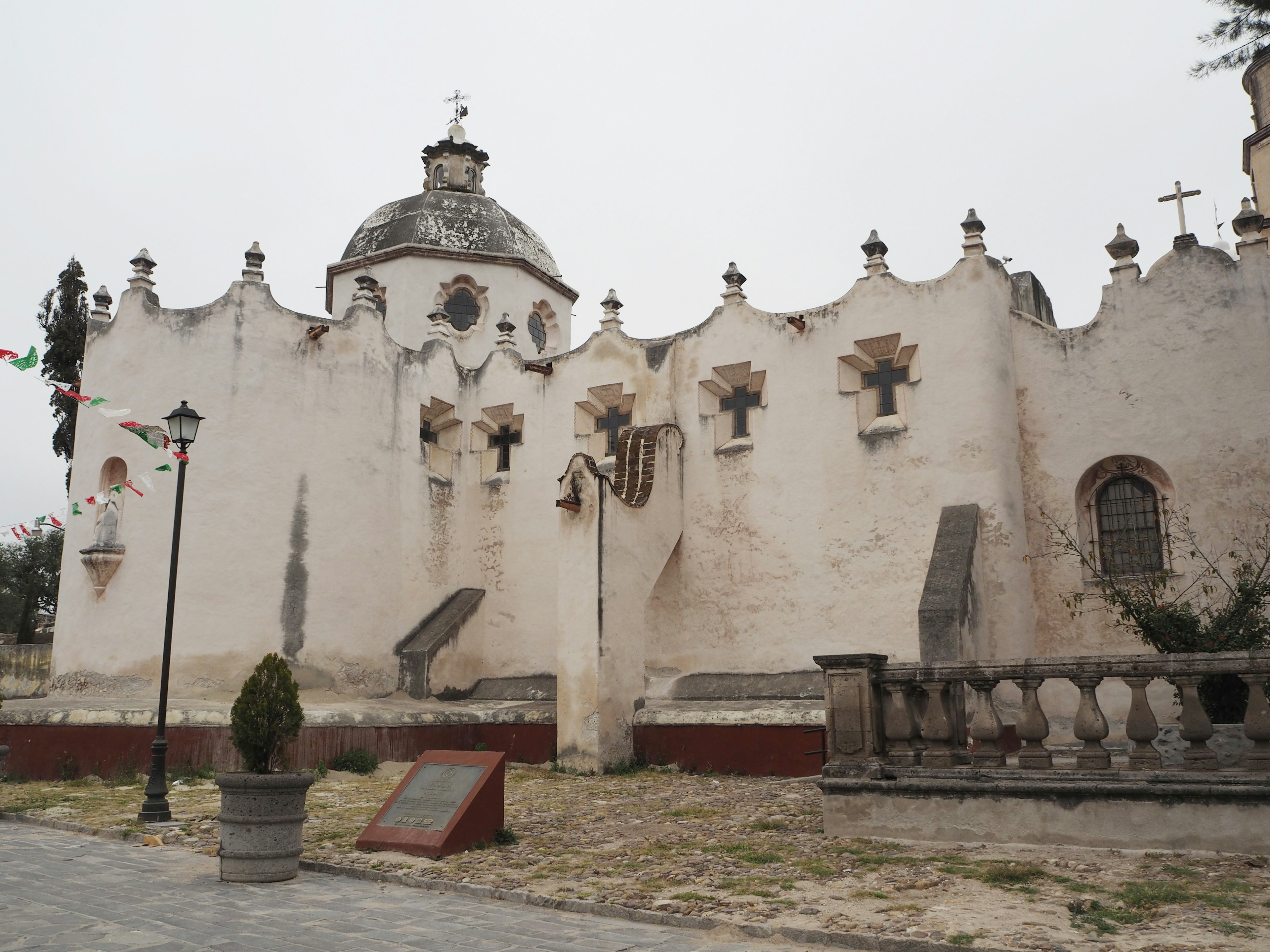 Vue extérieure d'une vieille église avec des murs blancs et des caractéristiques architecturales distinctives du toit