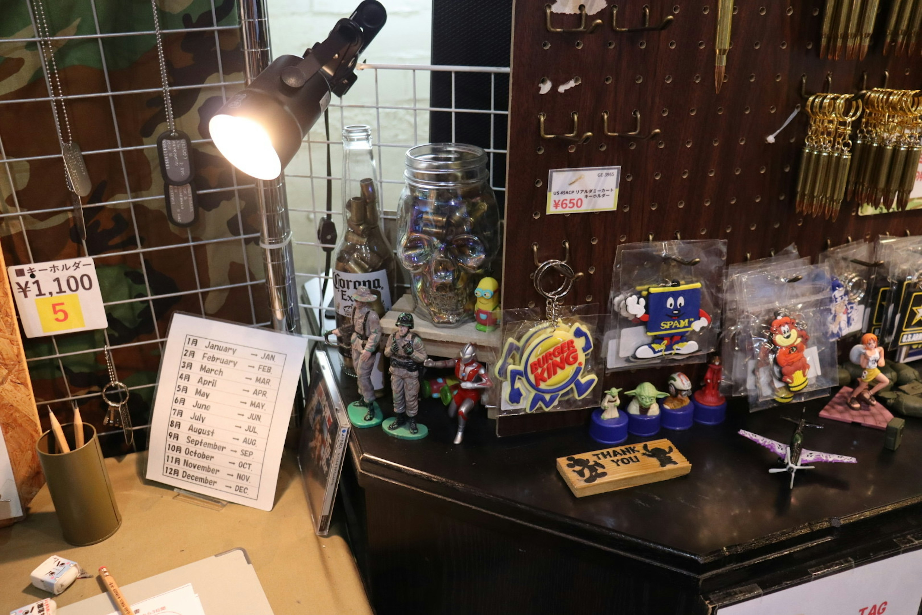 A workspace featuring various figurines and collectibles under a light source