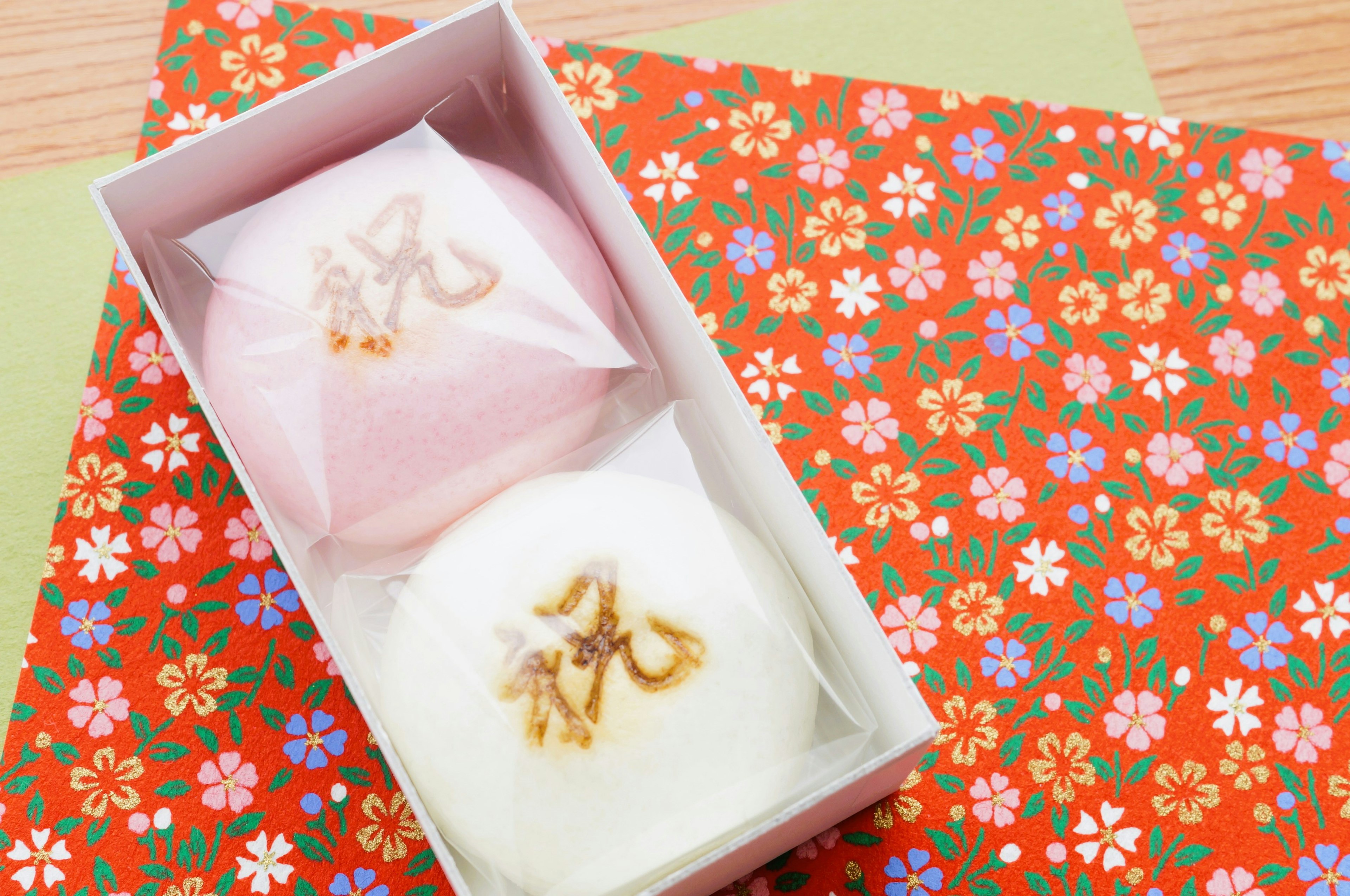 Two traditional Japanese sweets in a box pink and white colors floral patterned wrapping paper