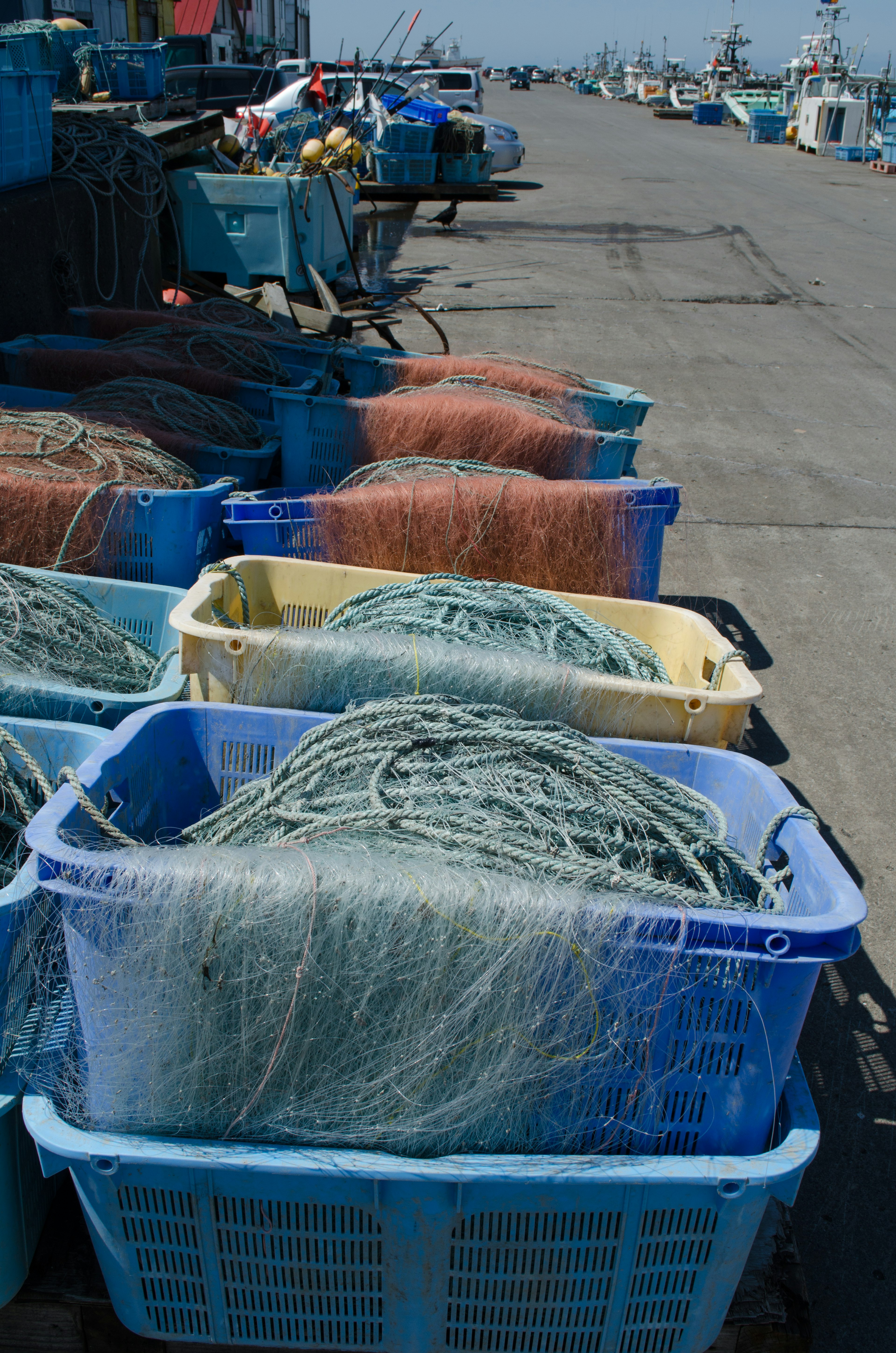 Fishing nets and gear in blue baskets at the harbor