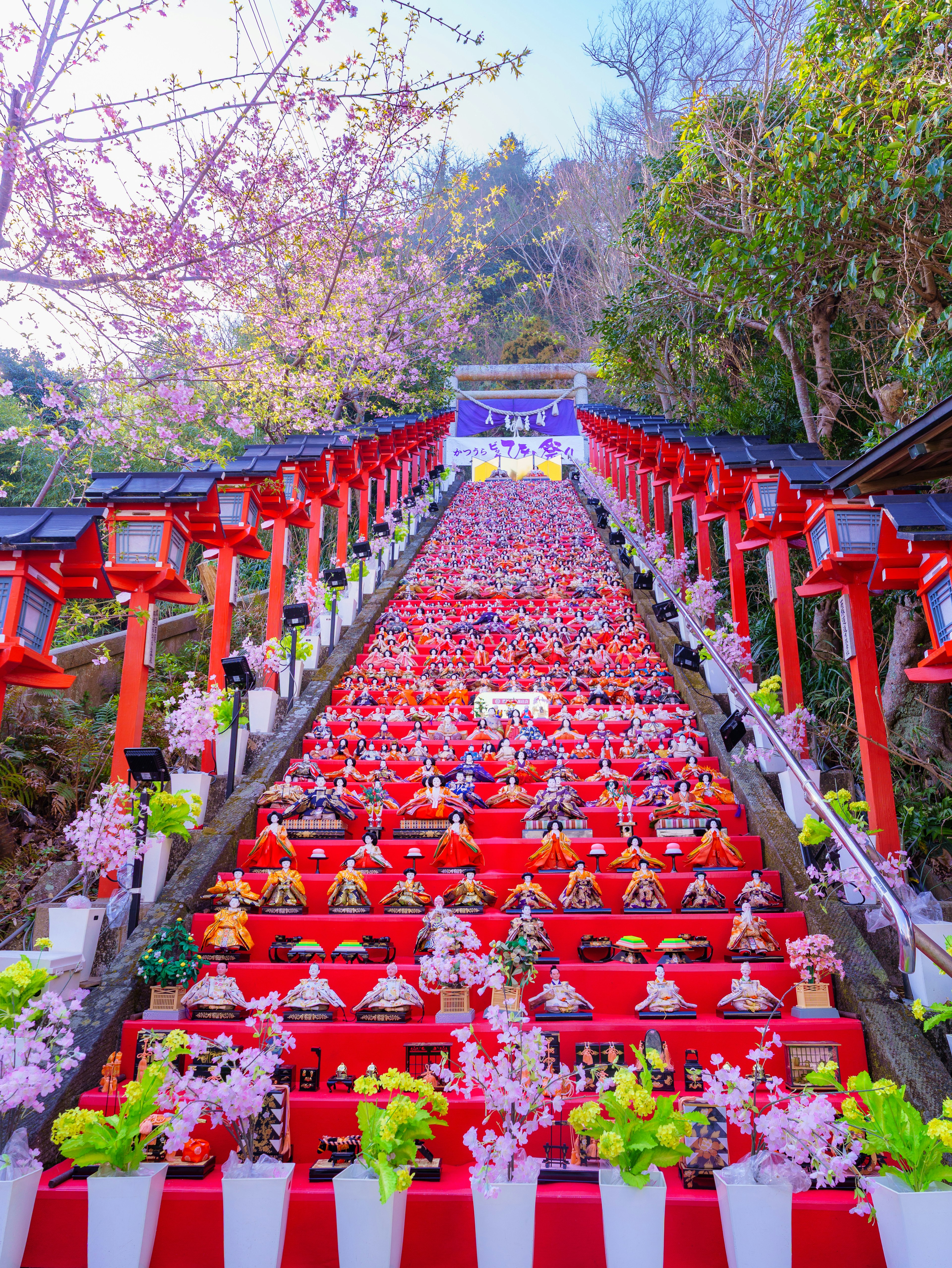 Escaleras adornadas con faroles rojos y flores de cerezo