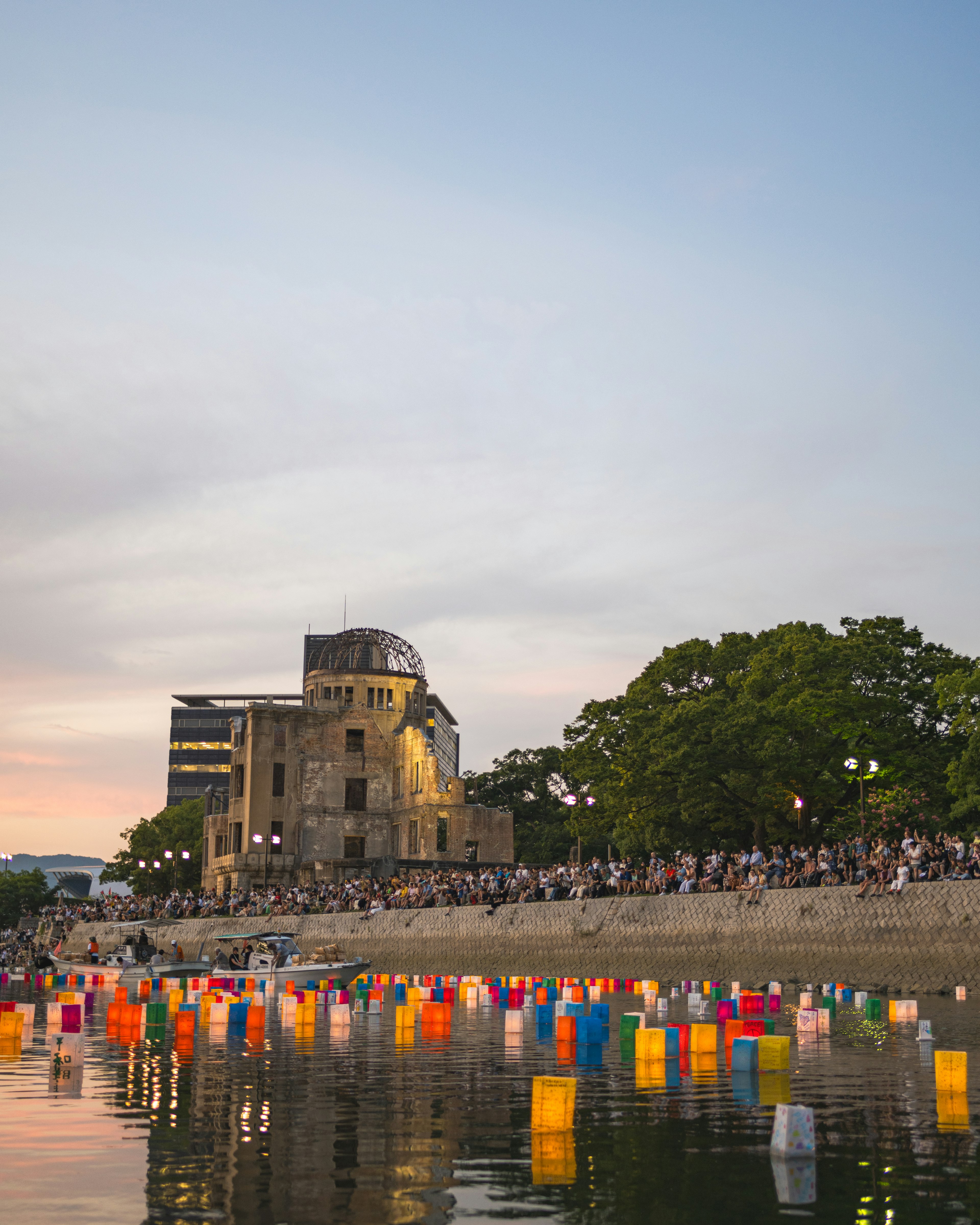 Colorful lanterns floating on the river in Hiroshima with a historic building