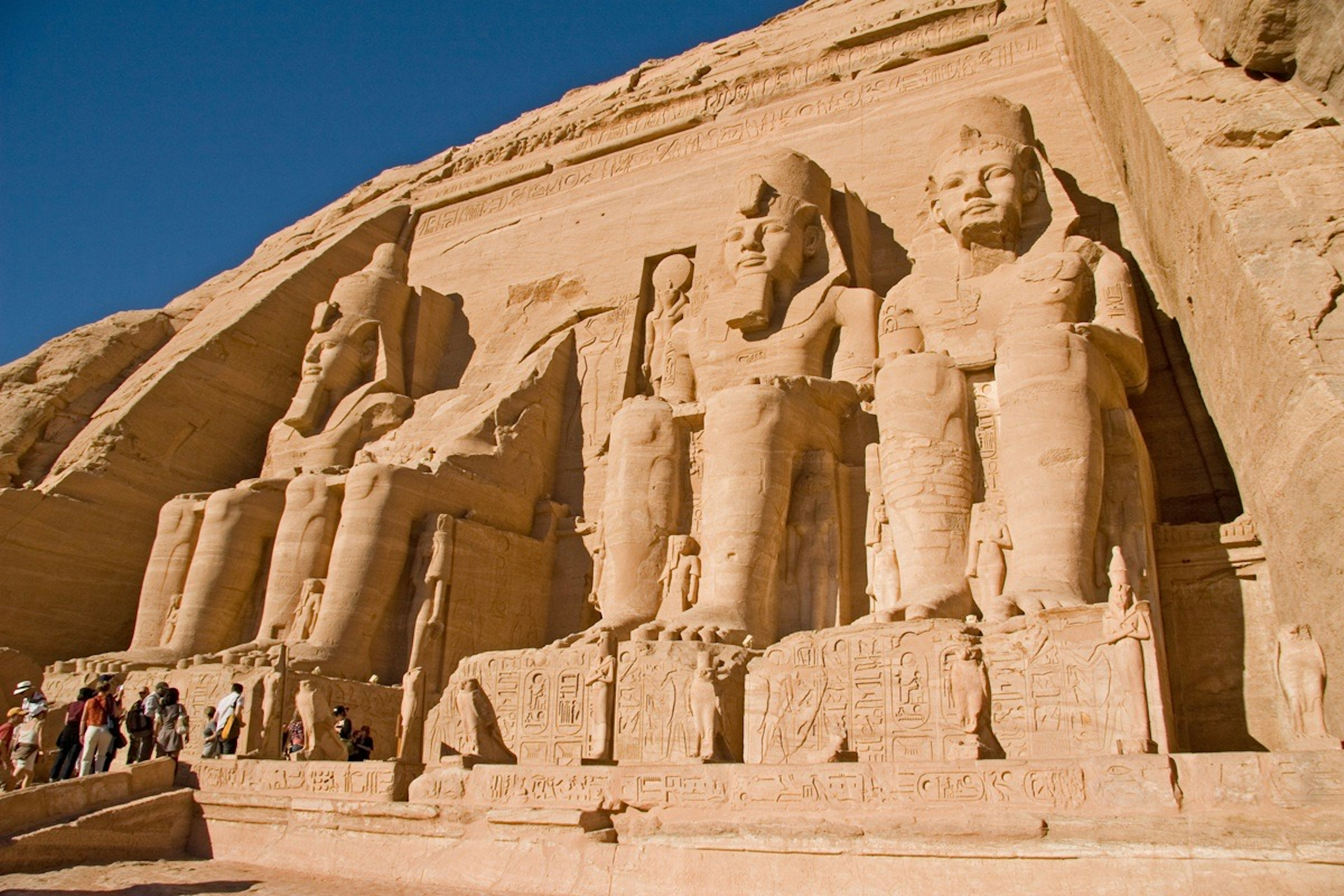 Massive rock carvings of Abu Simbel Temple in Egypt with tourists