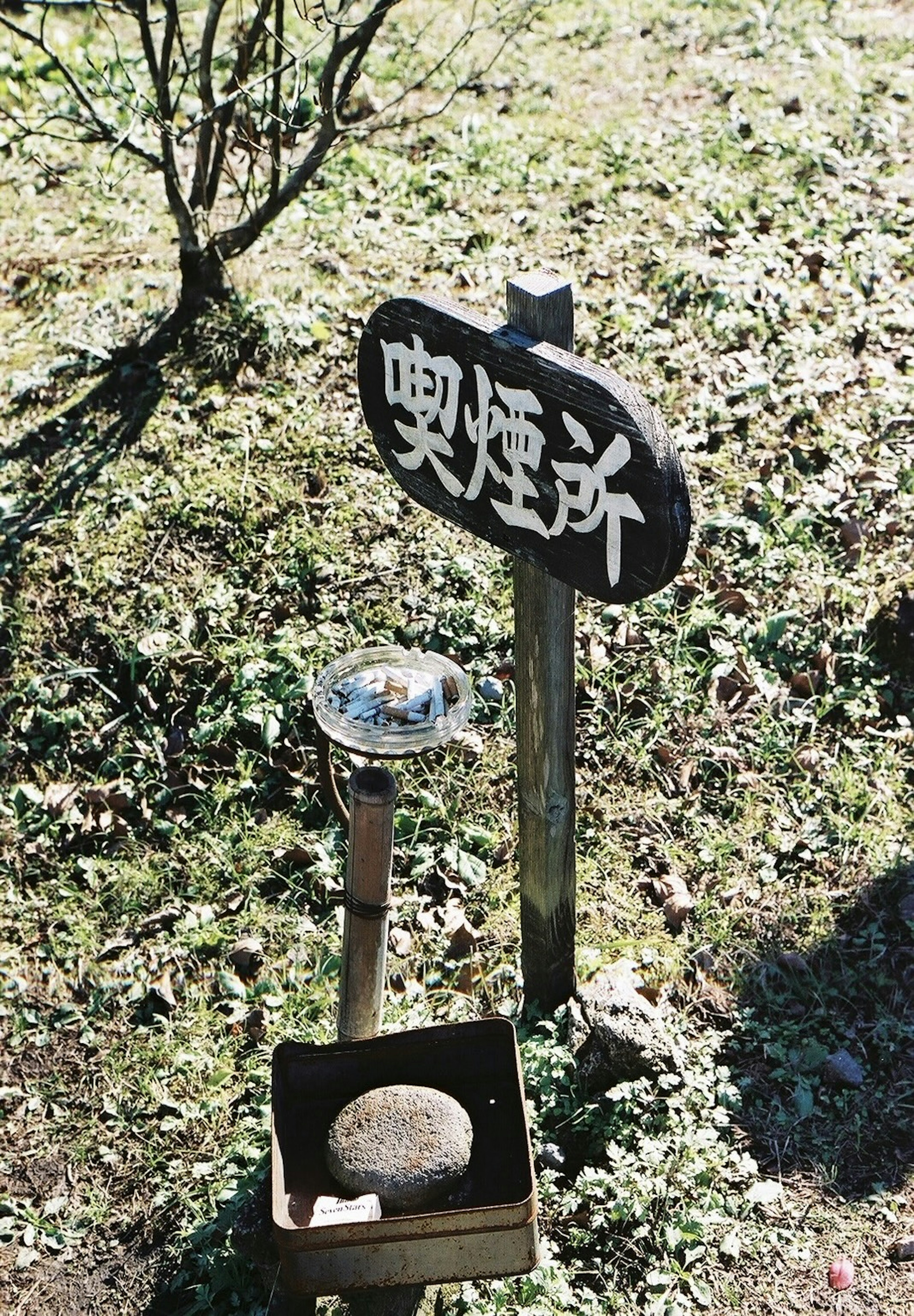 喫煙所の看板と煙草の灰皿がある風景