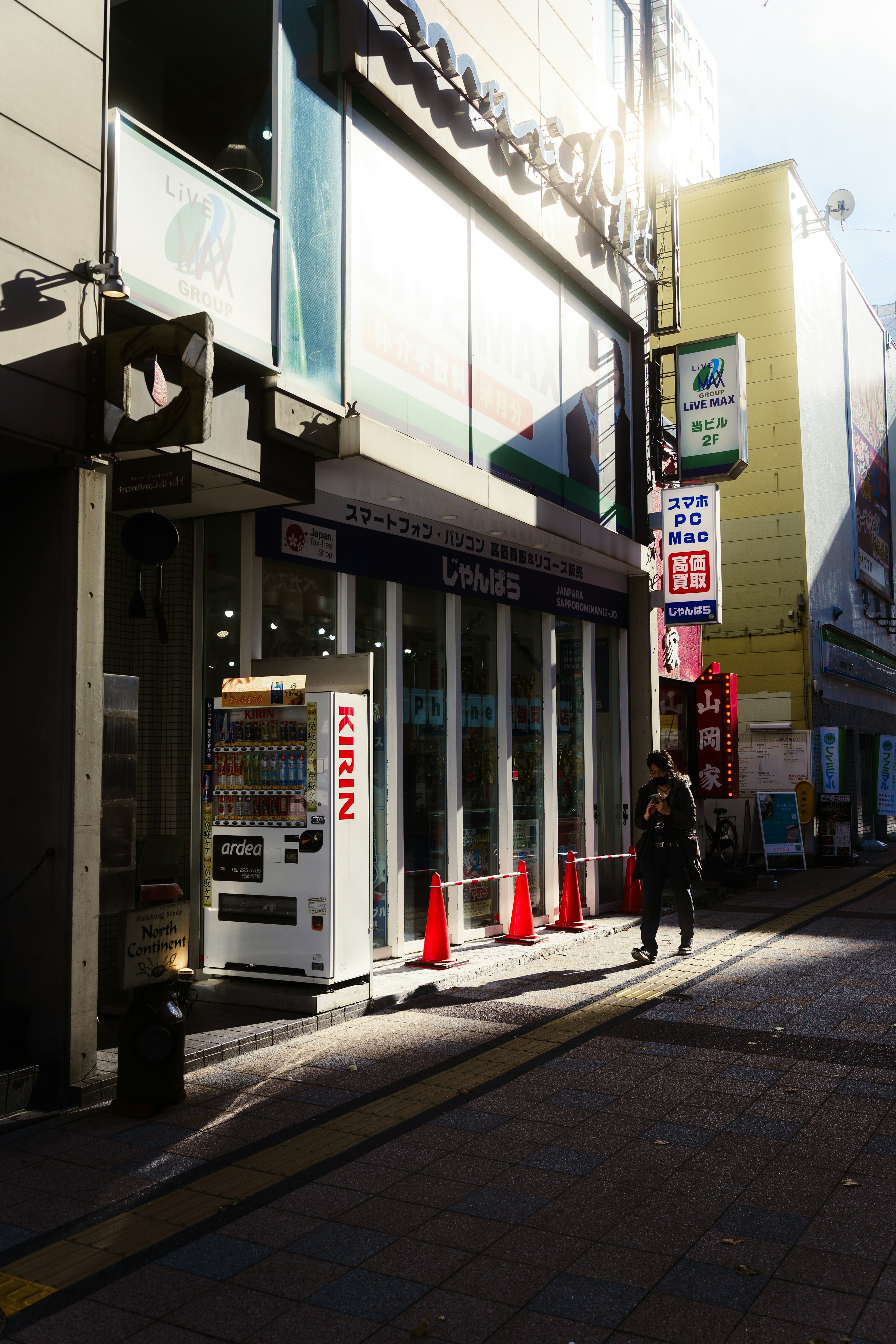 Vista di una strada luminosa con un caffè e un distributore automatico