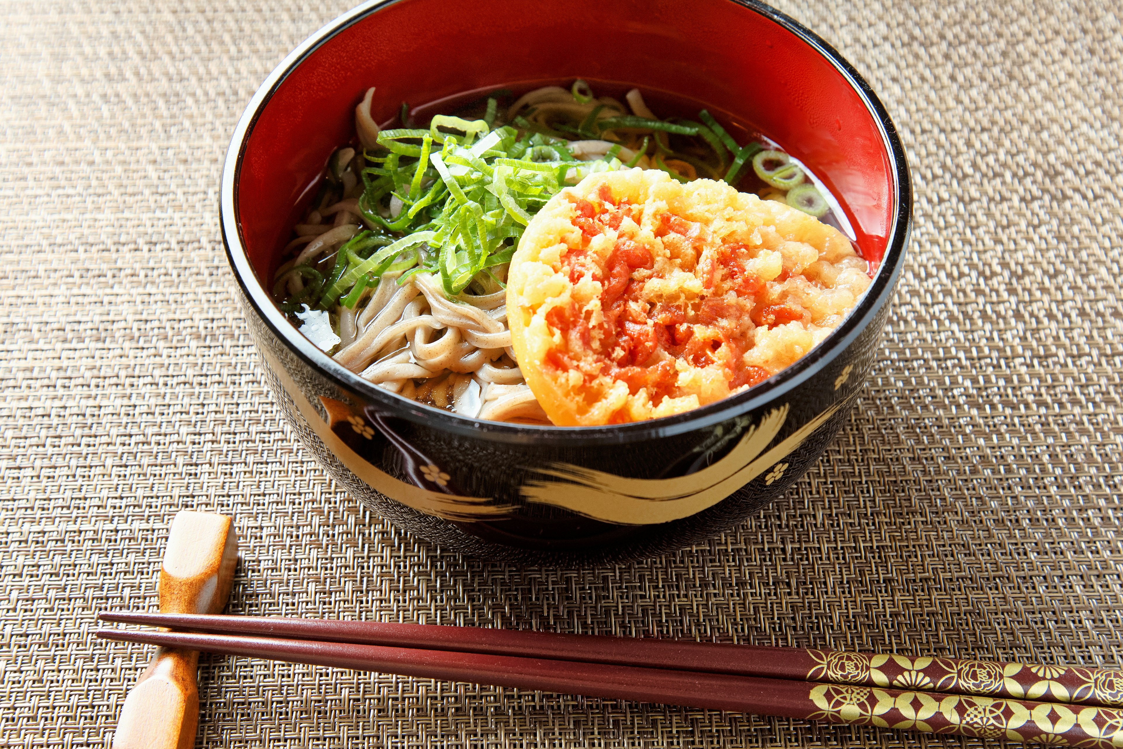 Bowl of soba noodles with tempura and green onions