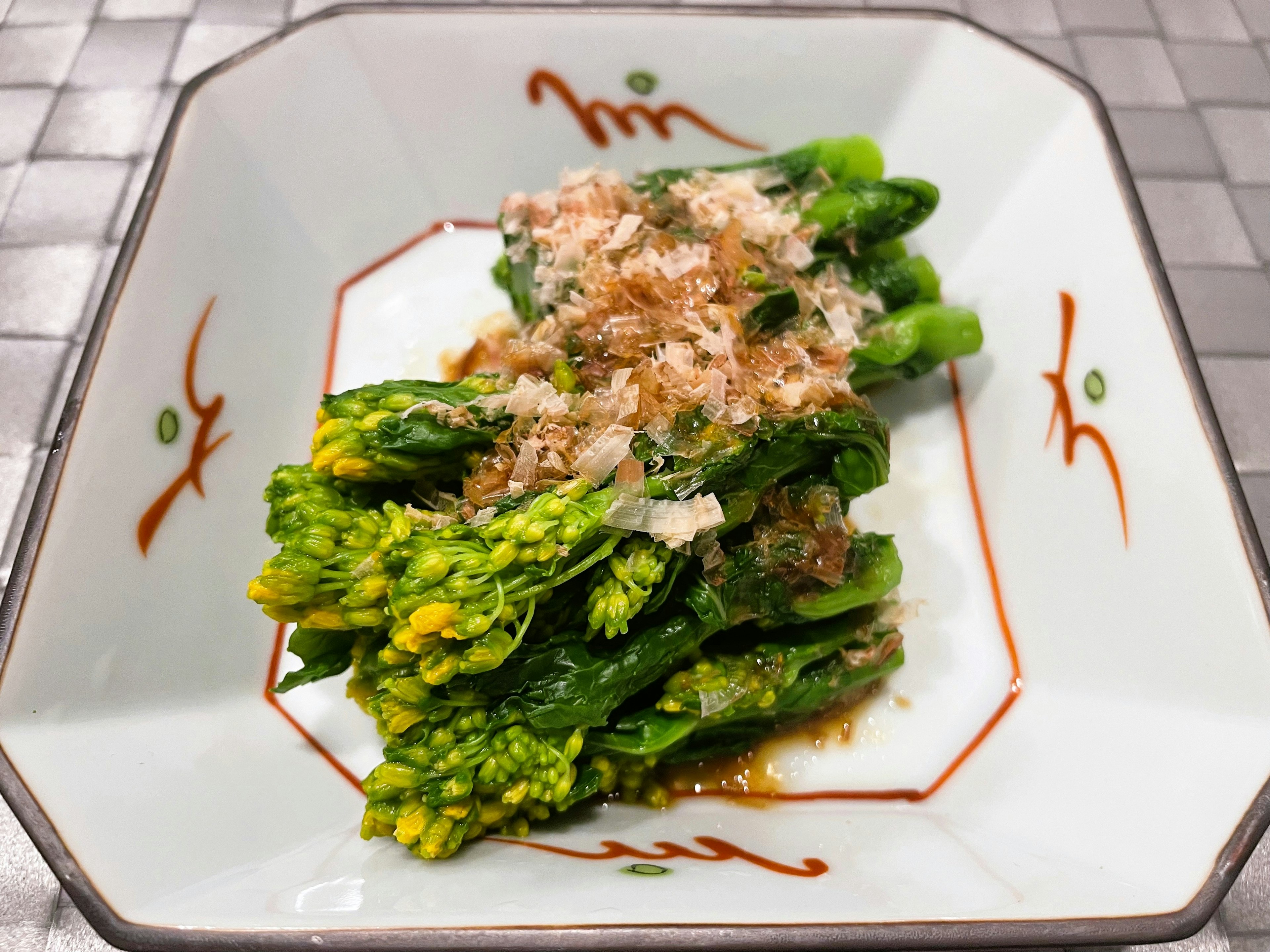 Asparagus yang disajikan dengan indah dan ditaburi serpihan bonito