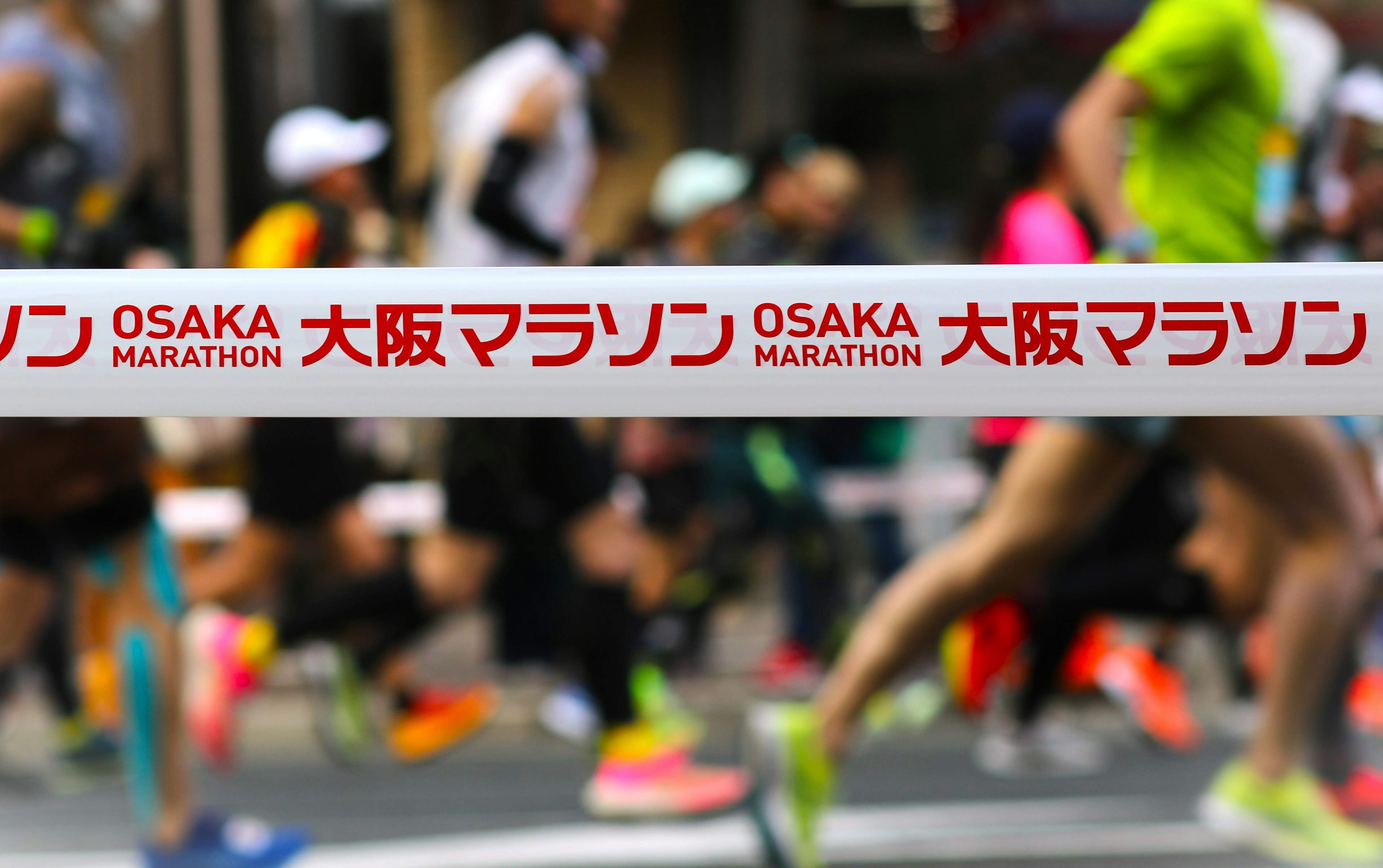 Runners crossing the finish line of the Osaka Marathon