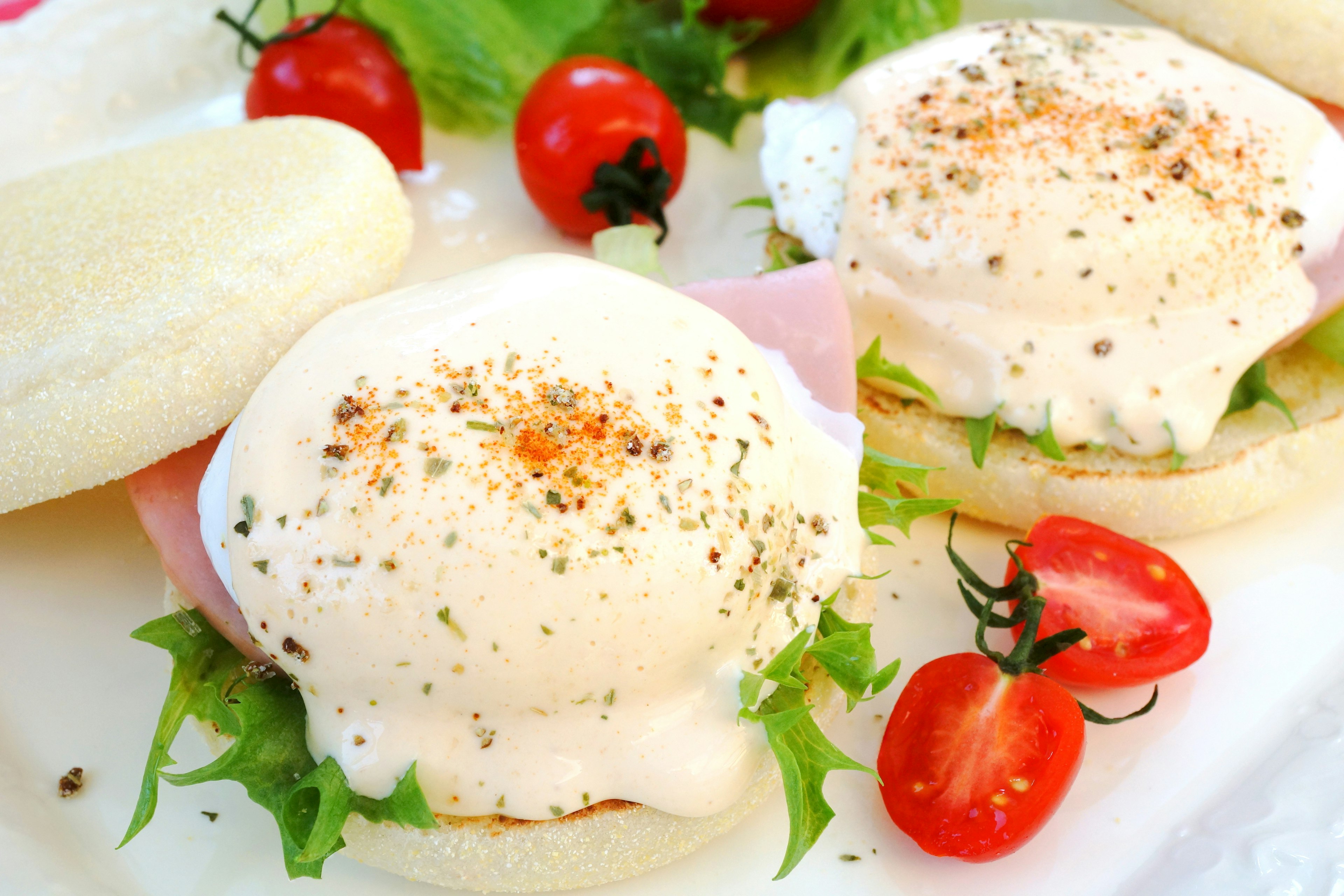 Teller mit Eggs Benedict garniert mit Kirschtomaten