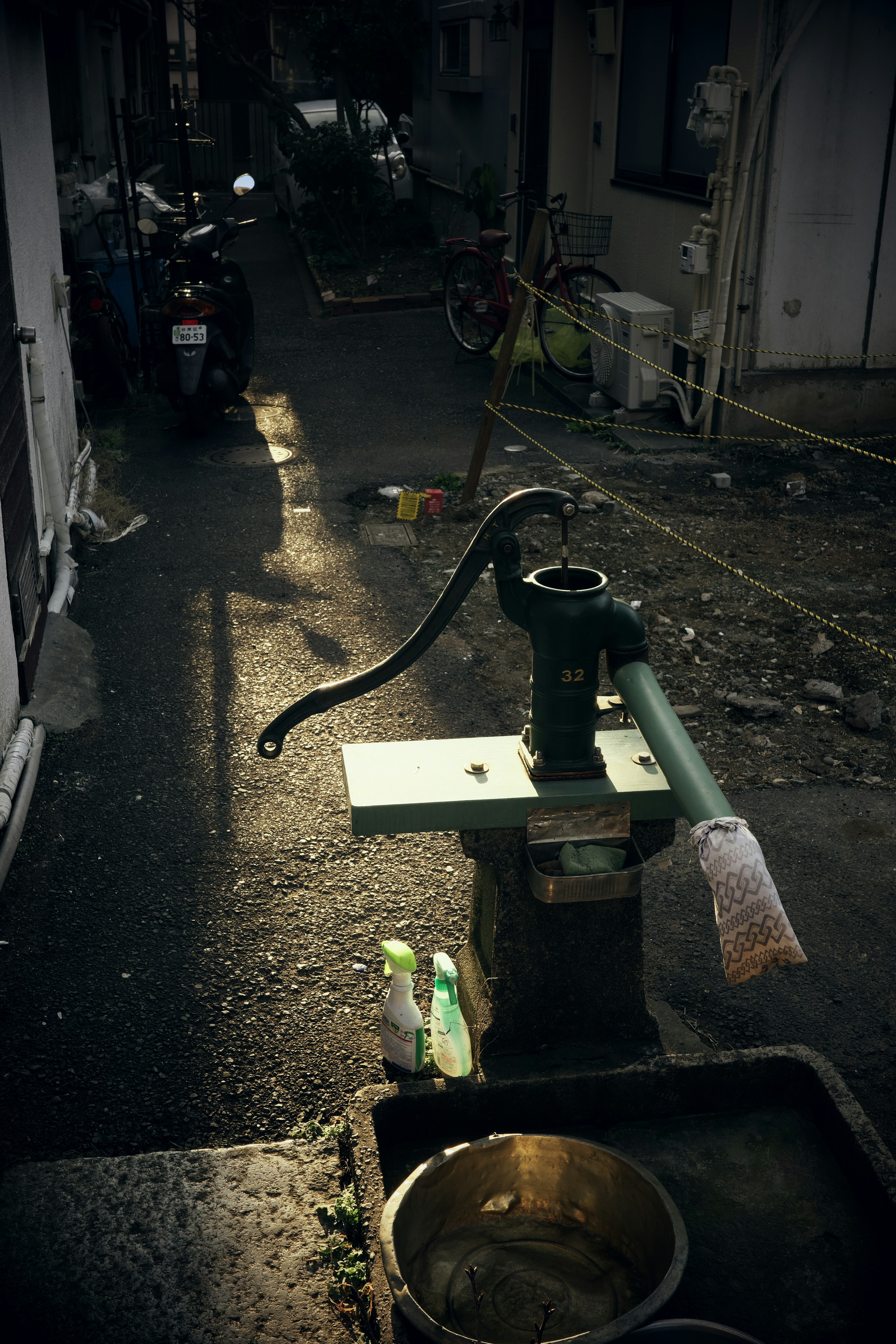 Old manual water pump in a narrow alleyway