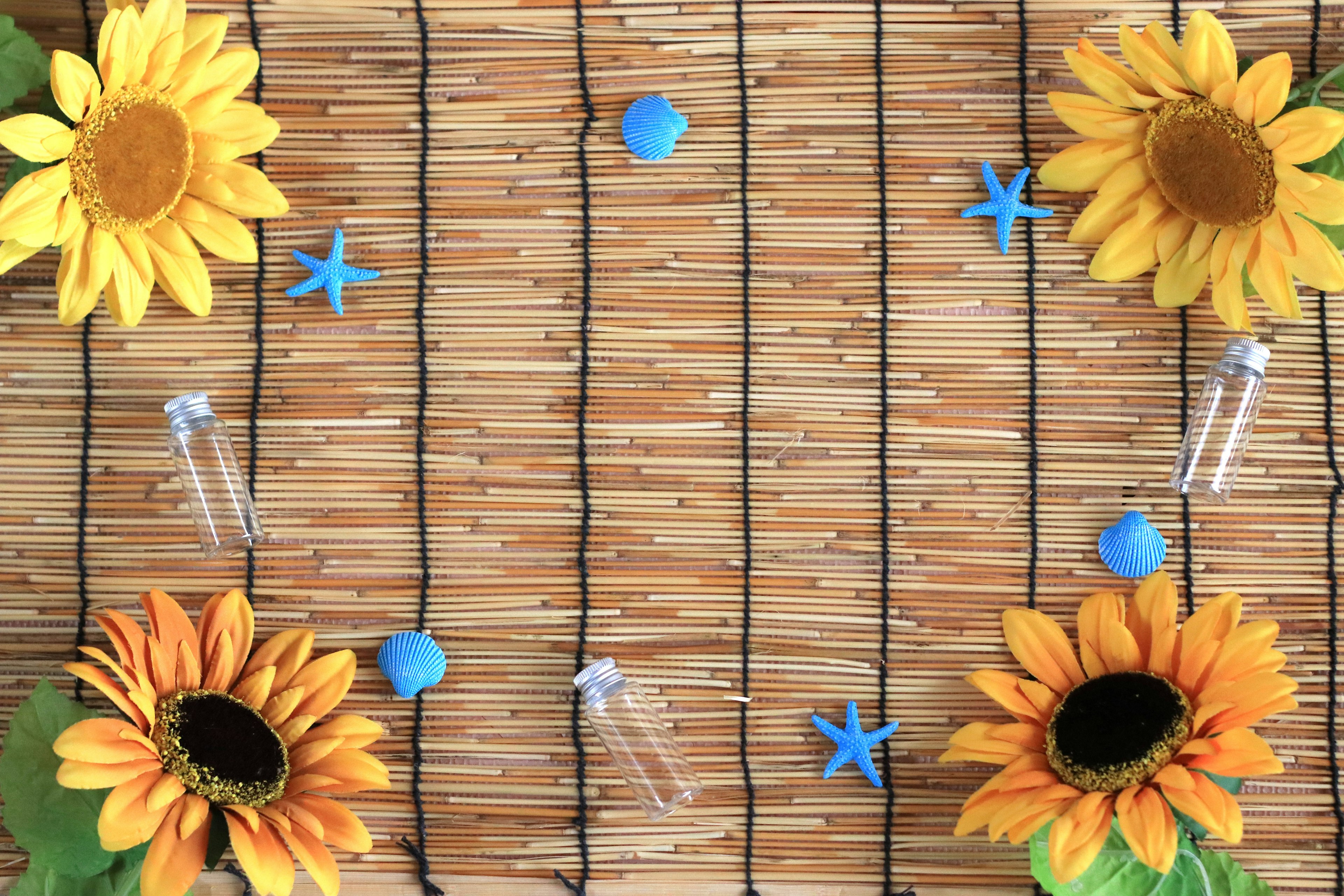 Girasoles y decoraciones azules dispuestos sobre un fondo de paja