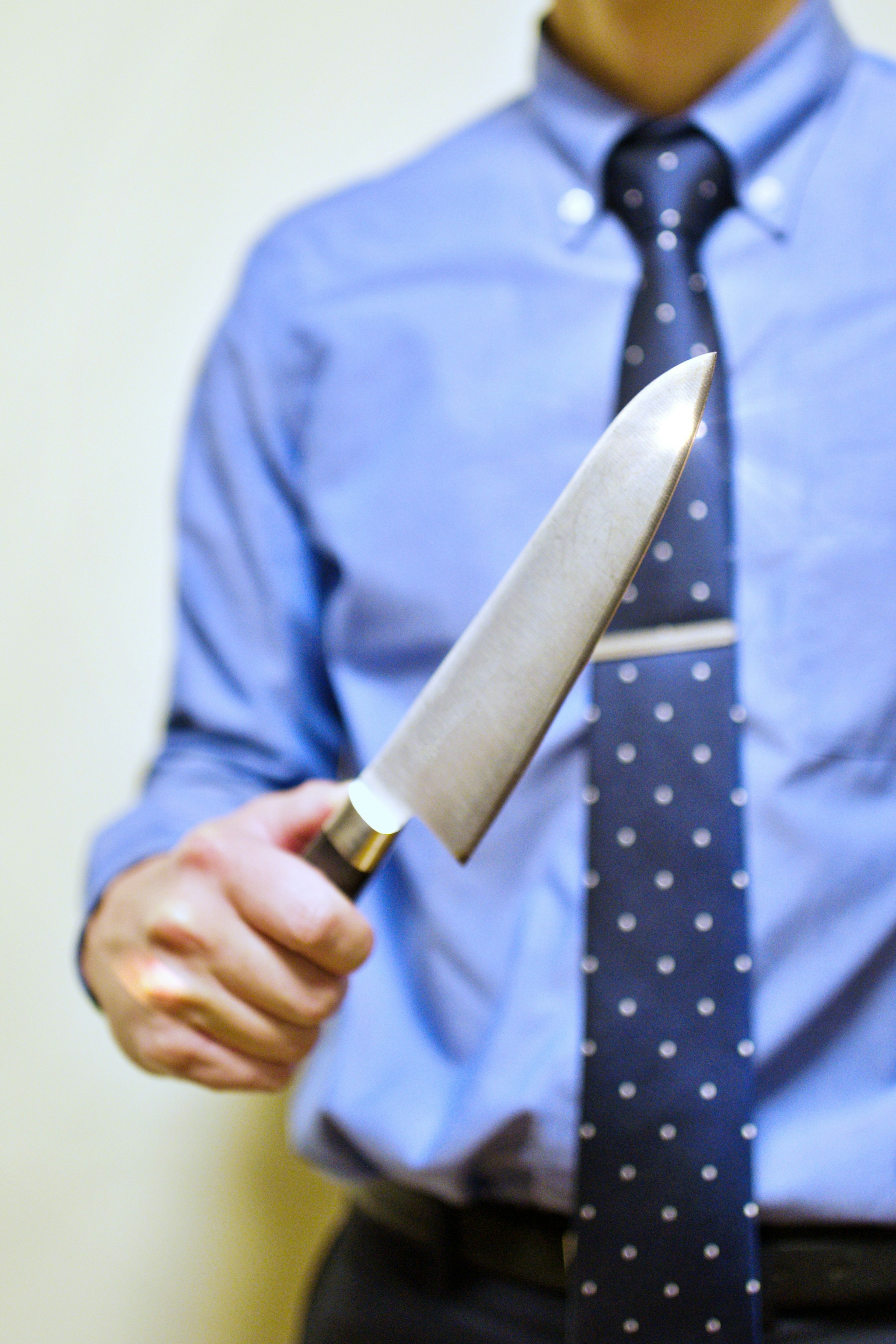 Man in a blue shirt holding a knife