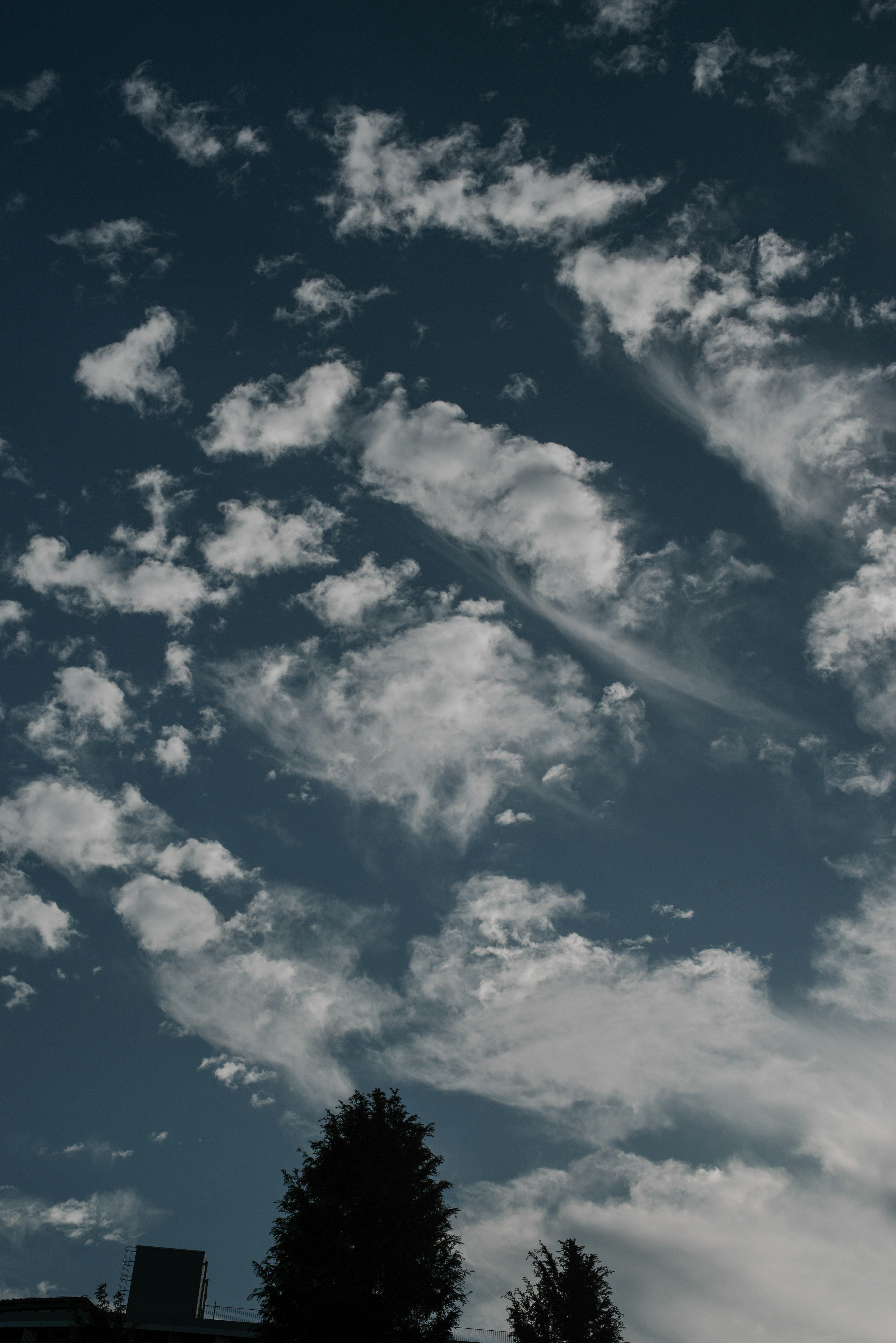 Un paysage avec des nuages blancs éparpillés dans un ciel bleu