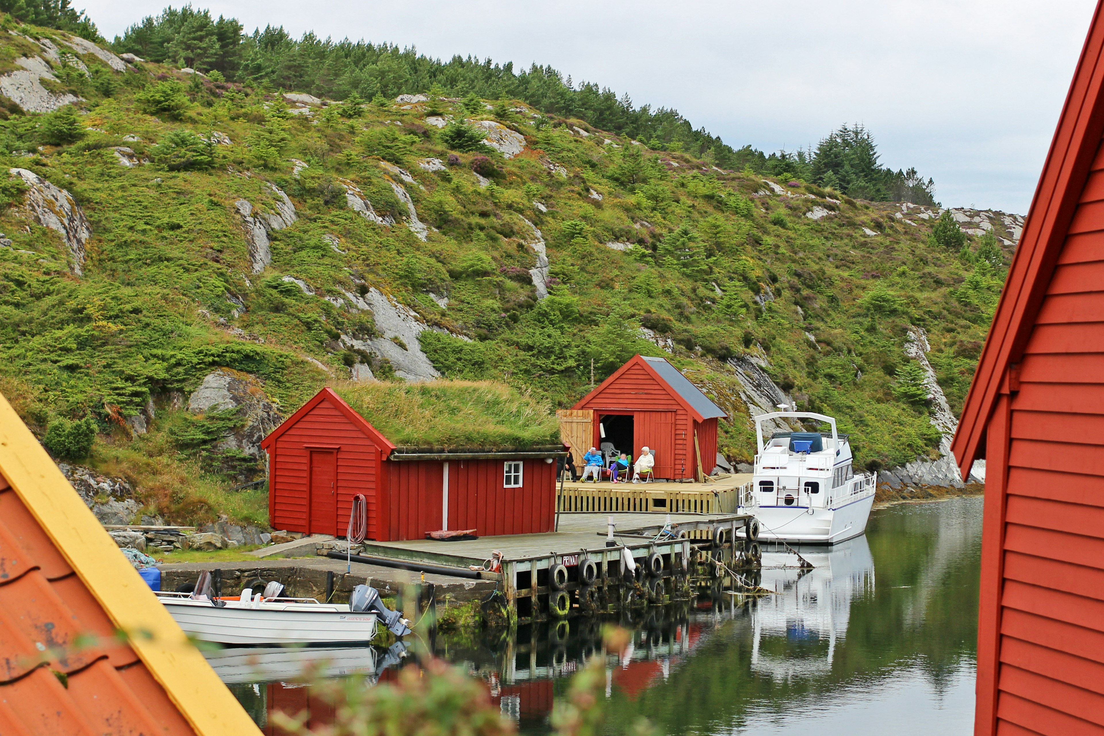 Scenic view of red cabins and a boat in a serene harbor