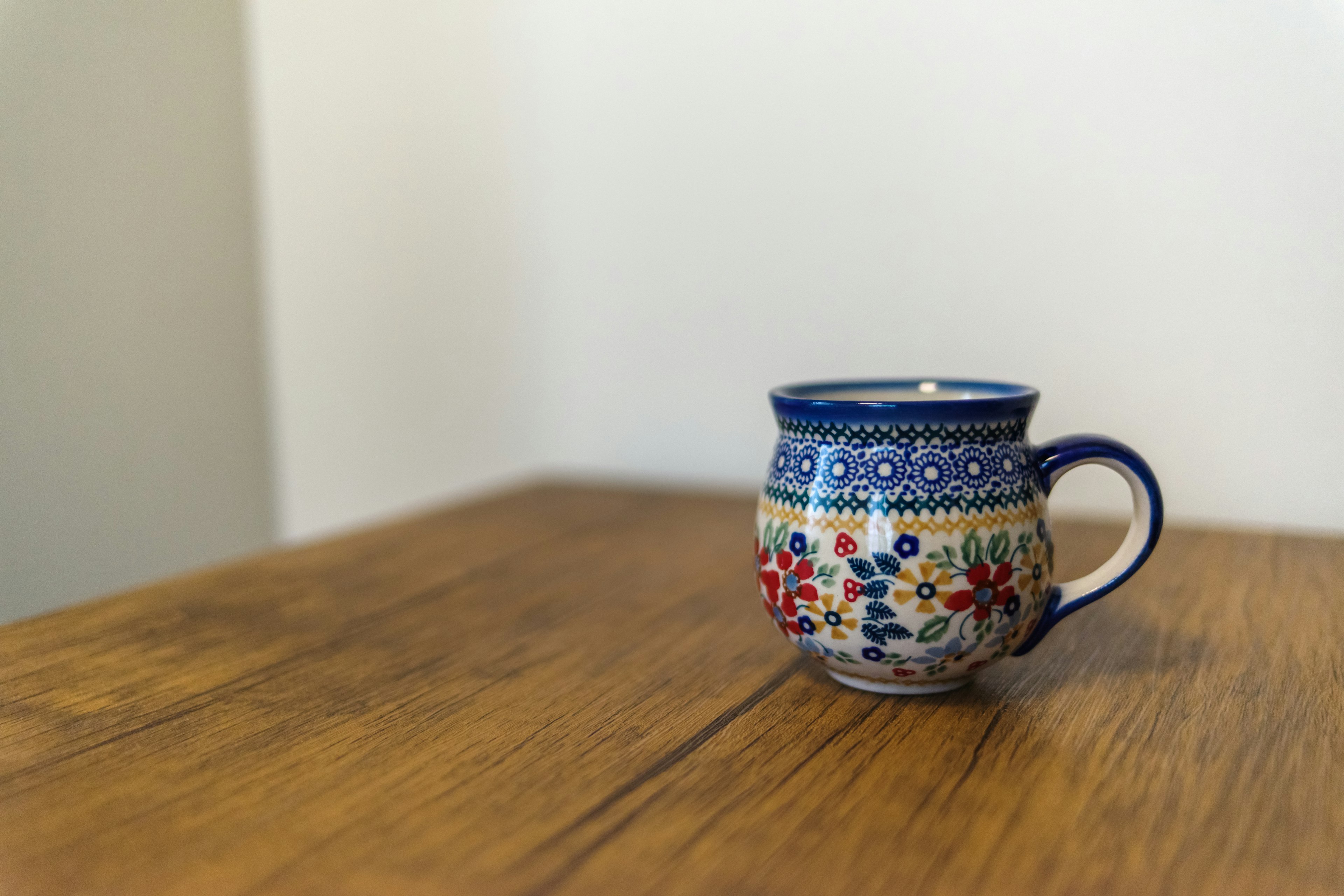 A blue decorated mug placed on a wooden table