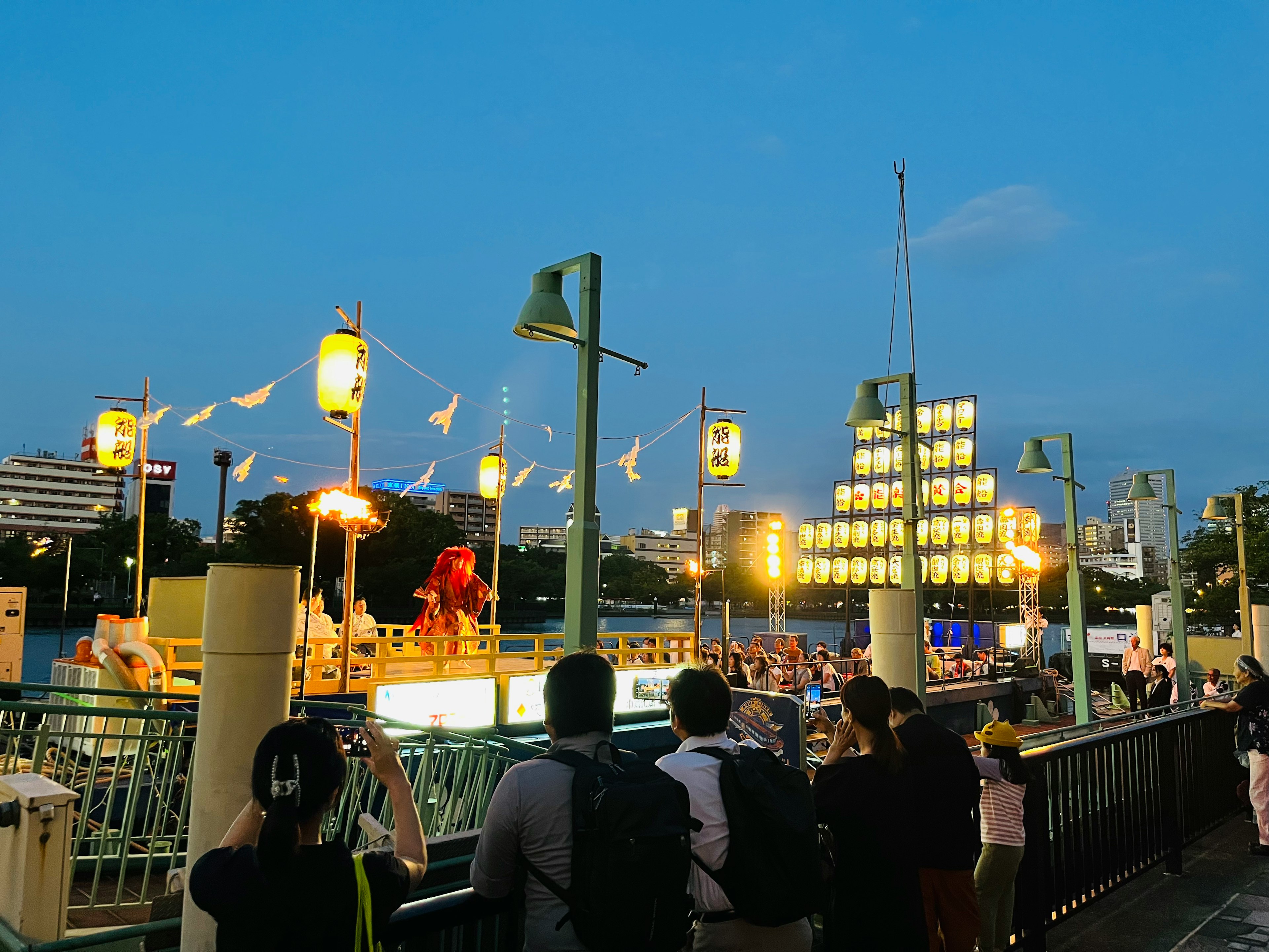 夜の祭りの様子で賑わう人々と提灯が並ぶ風景