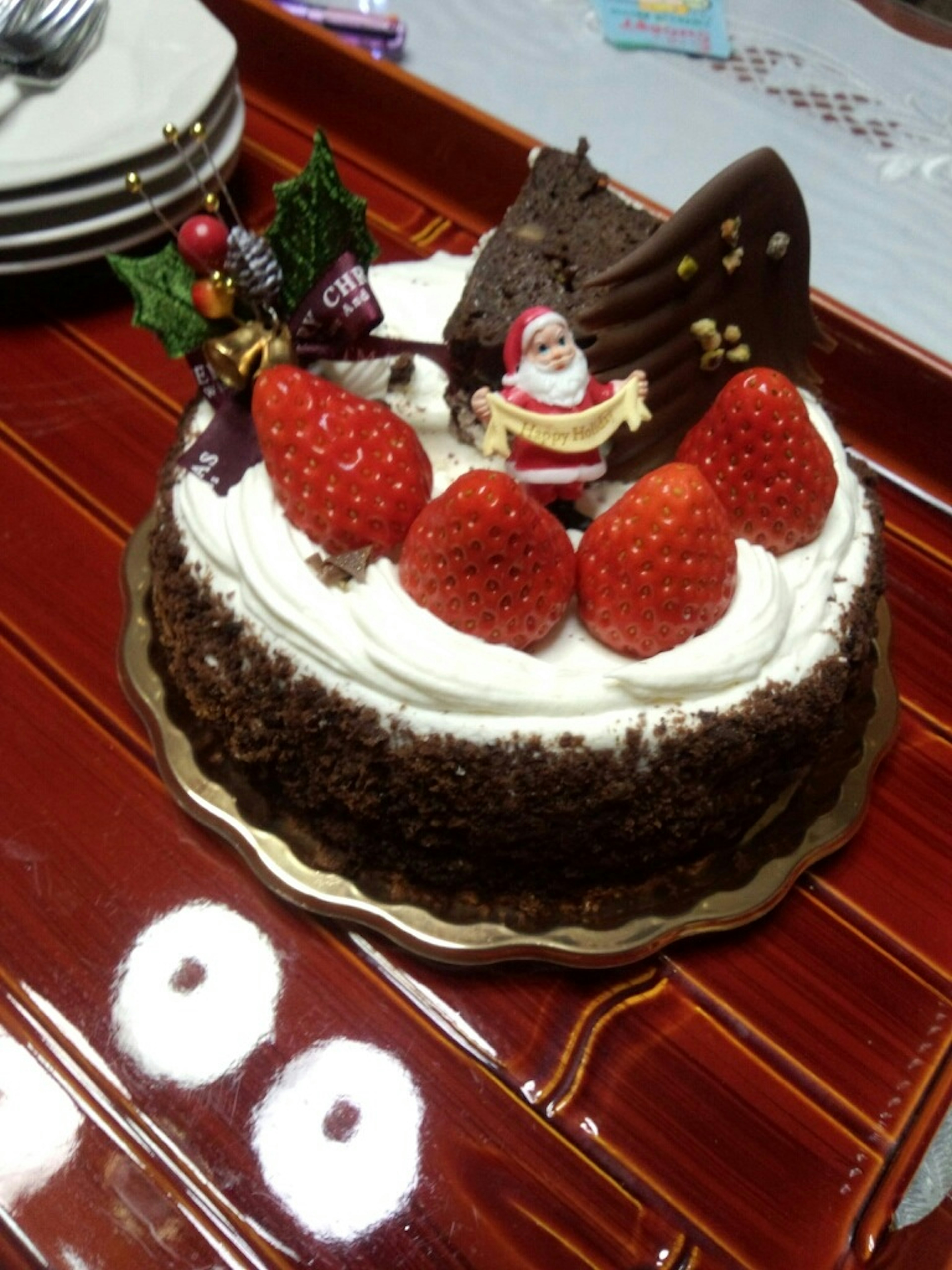 Christmas cake topped with strawberries and a Santa decoration