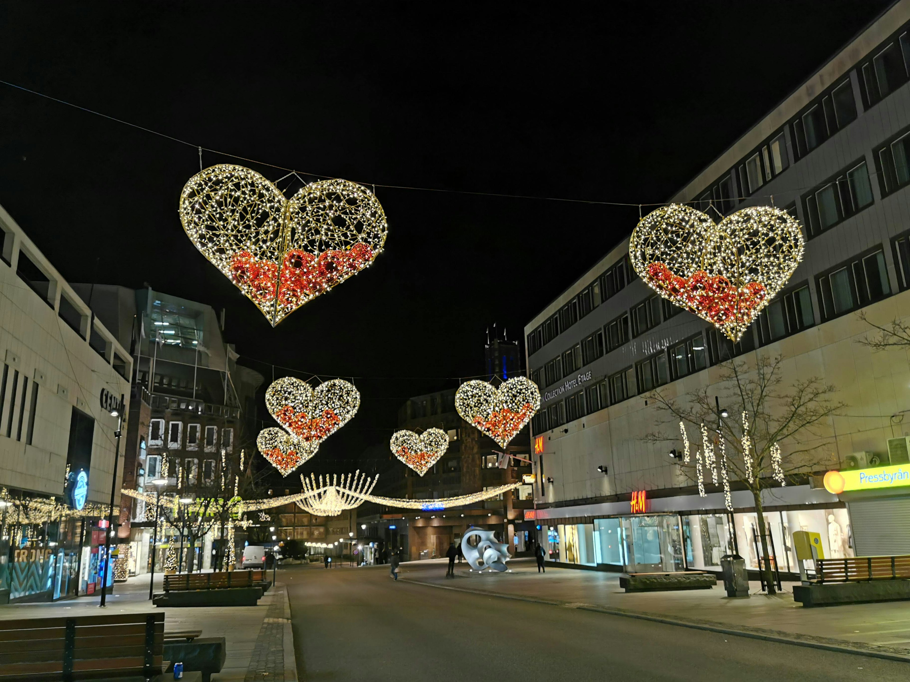 Des lumières en forme de cœur illuminant une rue la nuit