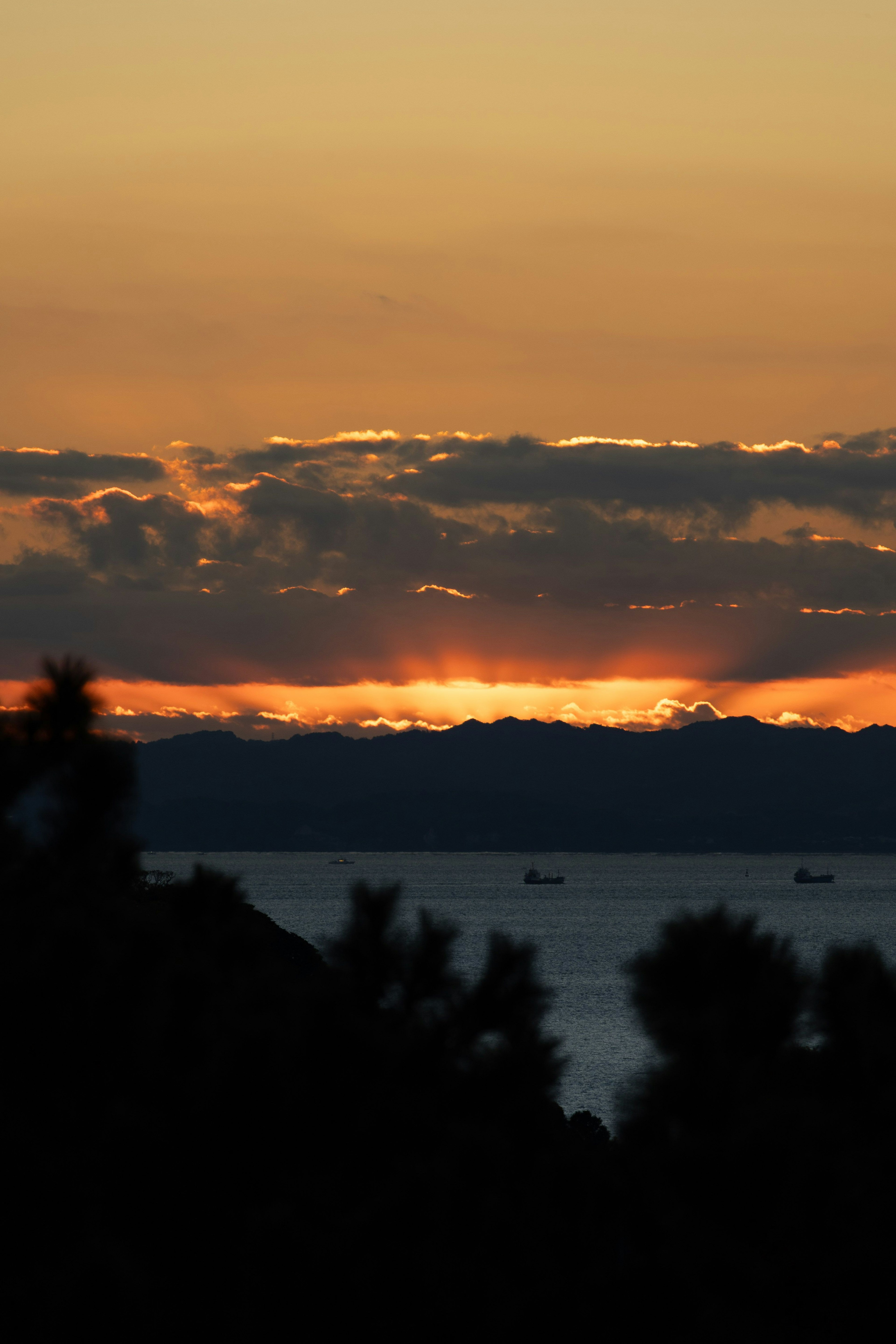 夕日が沈む海の風景と雲のシルエット