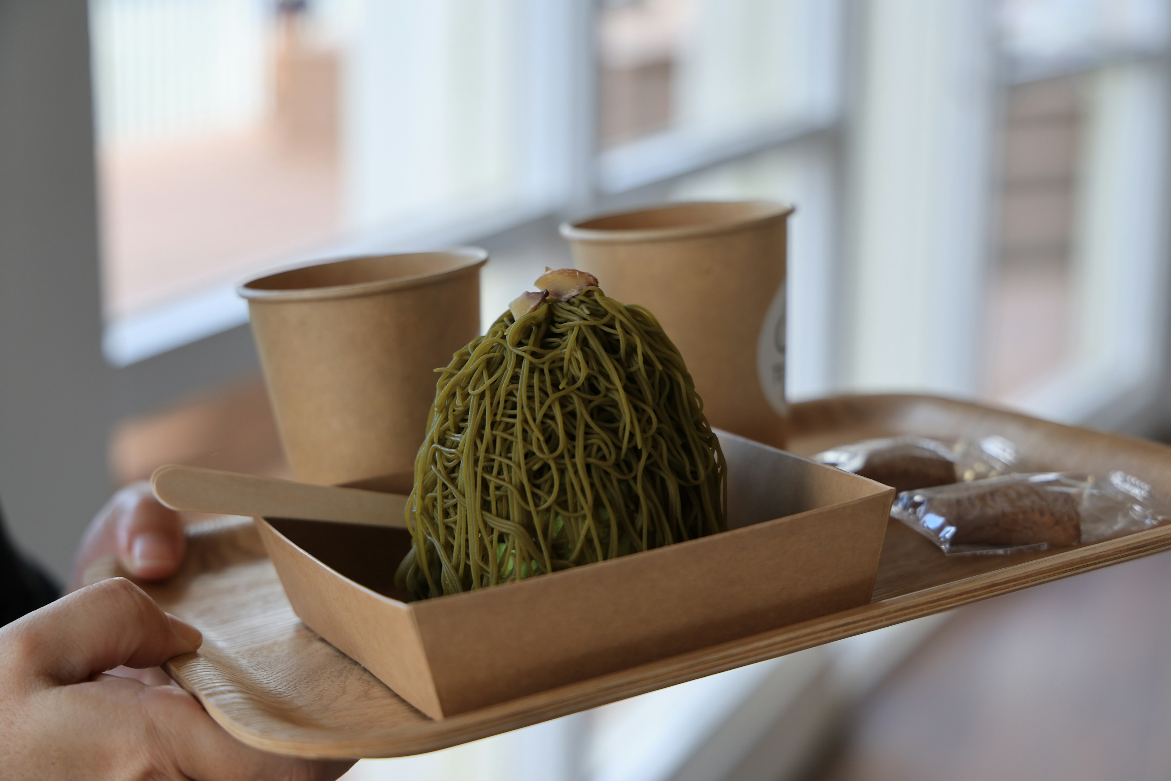 Matcha-Mont-Blanc-Kuchen mit Pappbechern auf einem Tablett