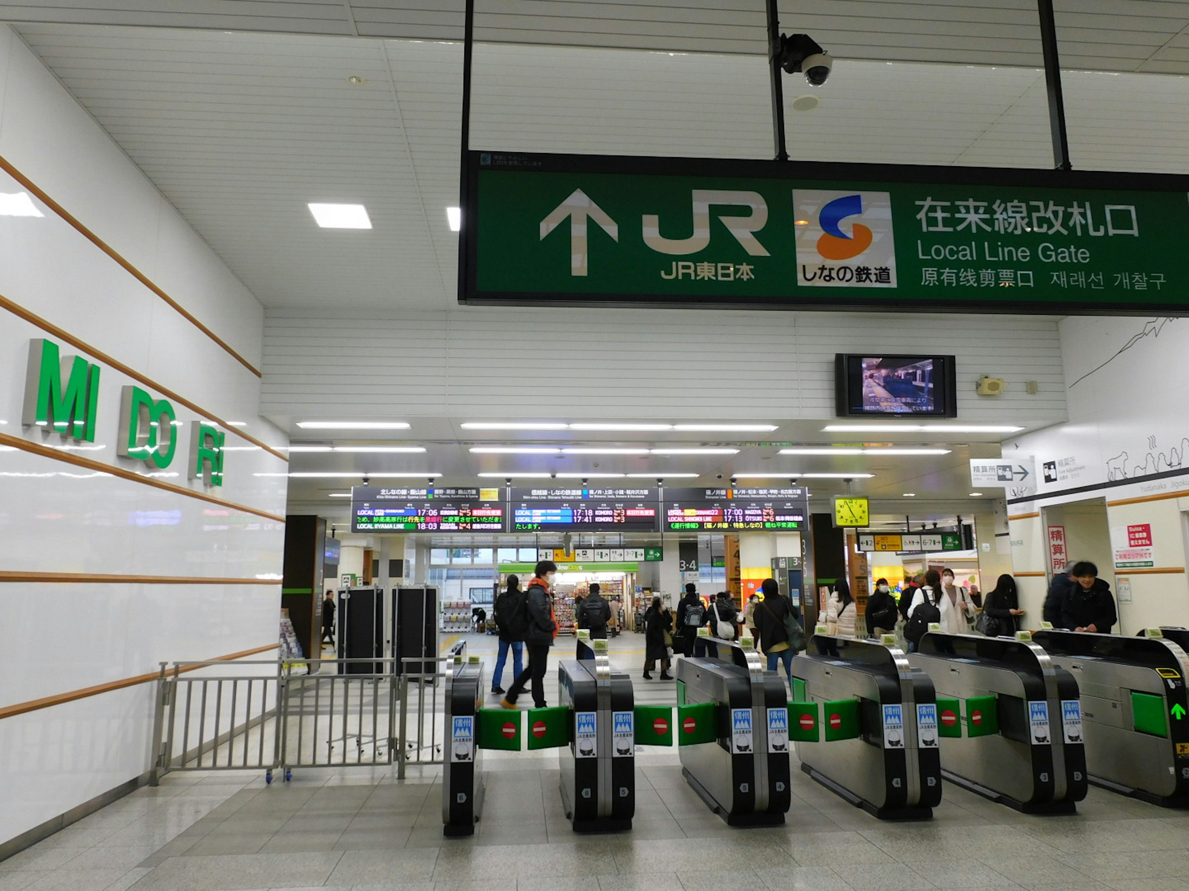 Station ticket gate with JR sign and people passing through