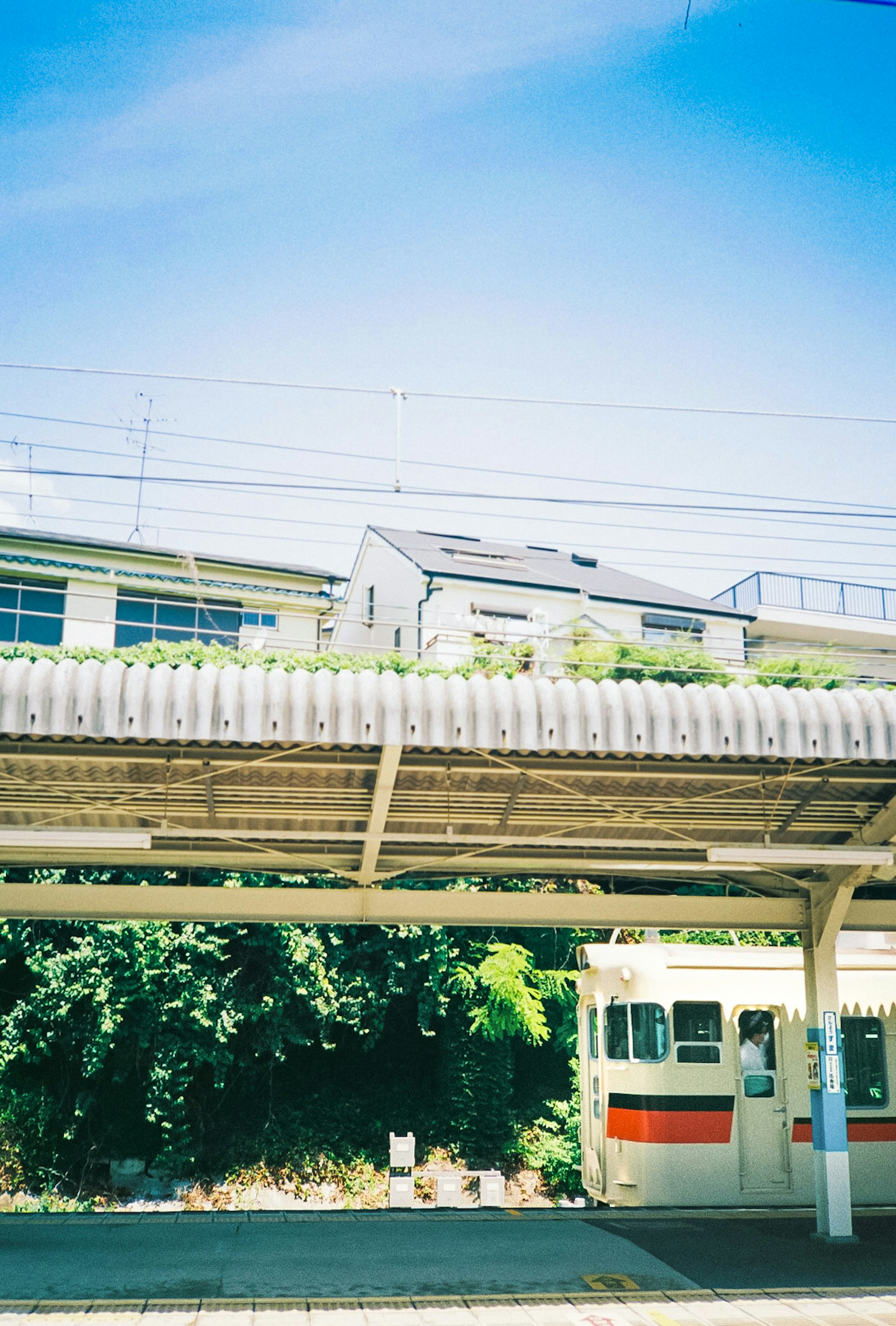 Train station platform under a blue sky with an old train