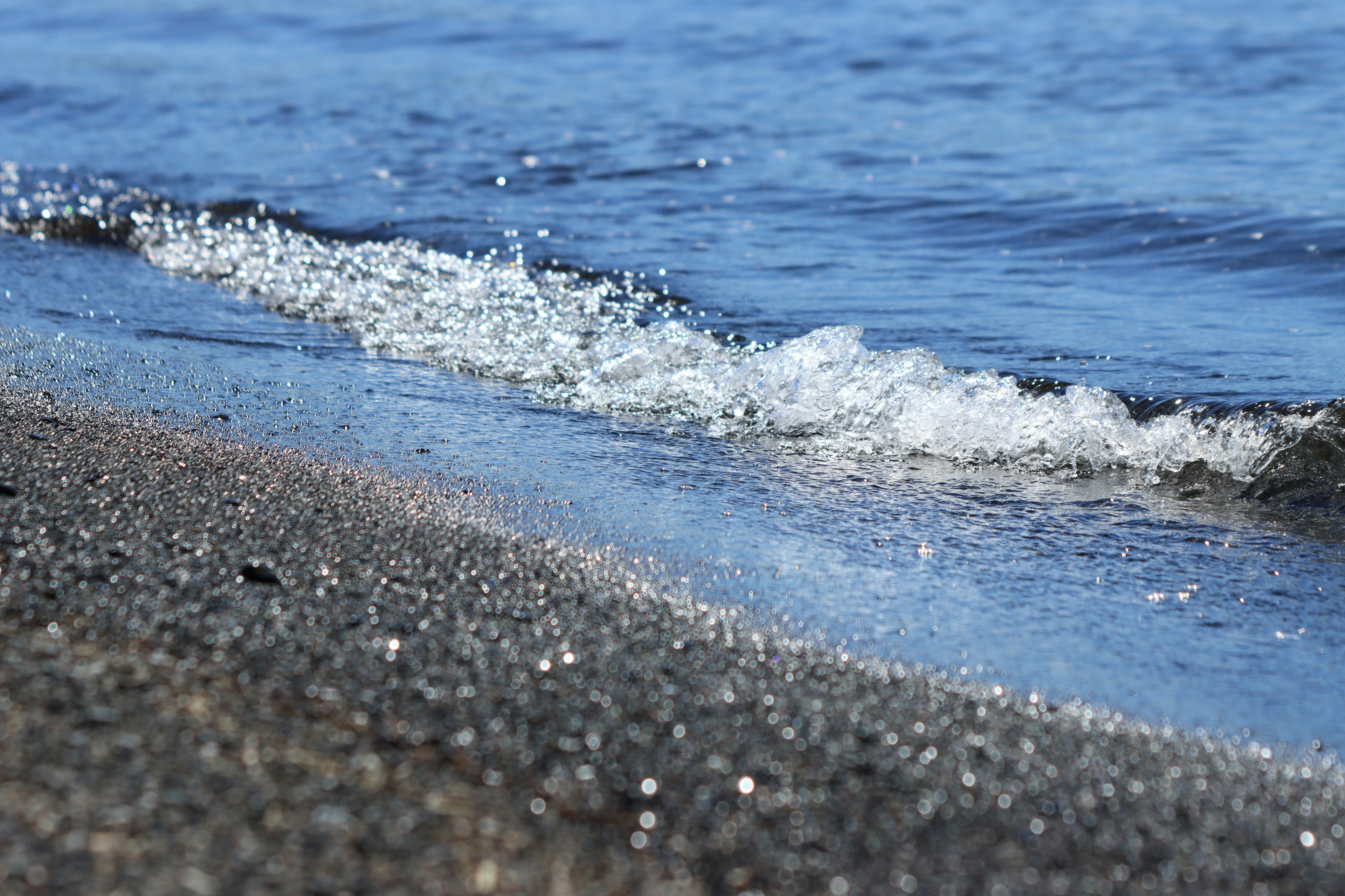 Waves lapping on a black sandy beach