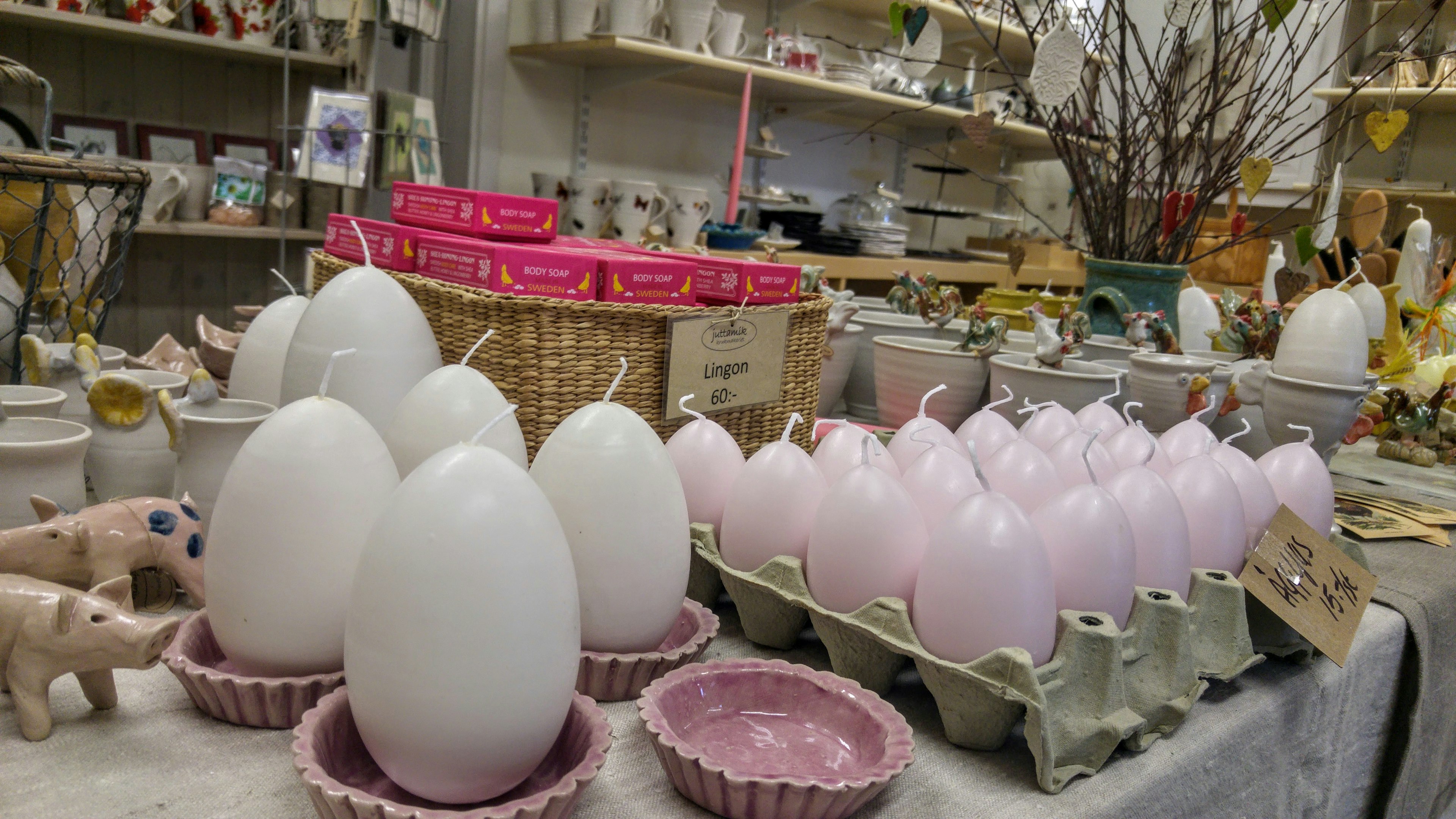 Des œufs blancs et roses disposés sur une table avec des objets décoratifs