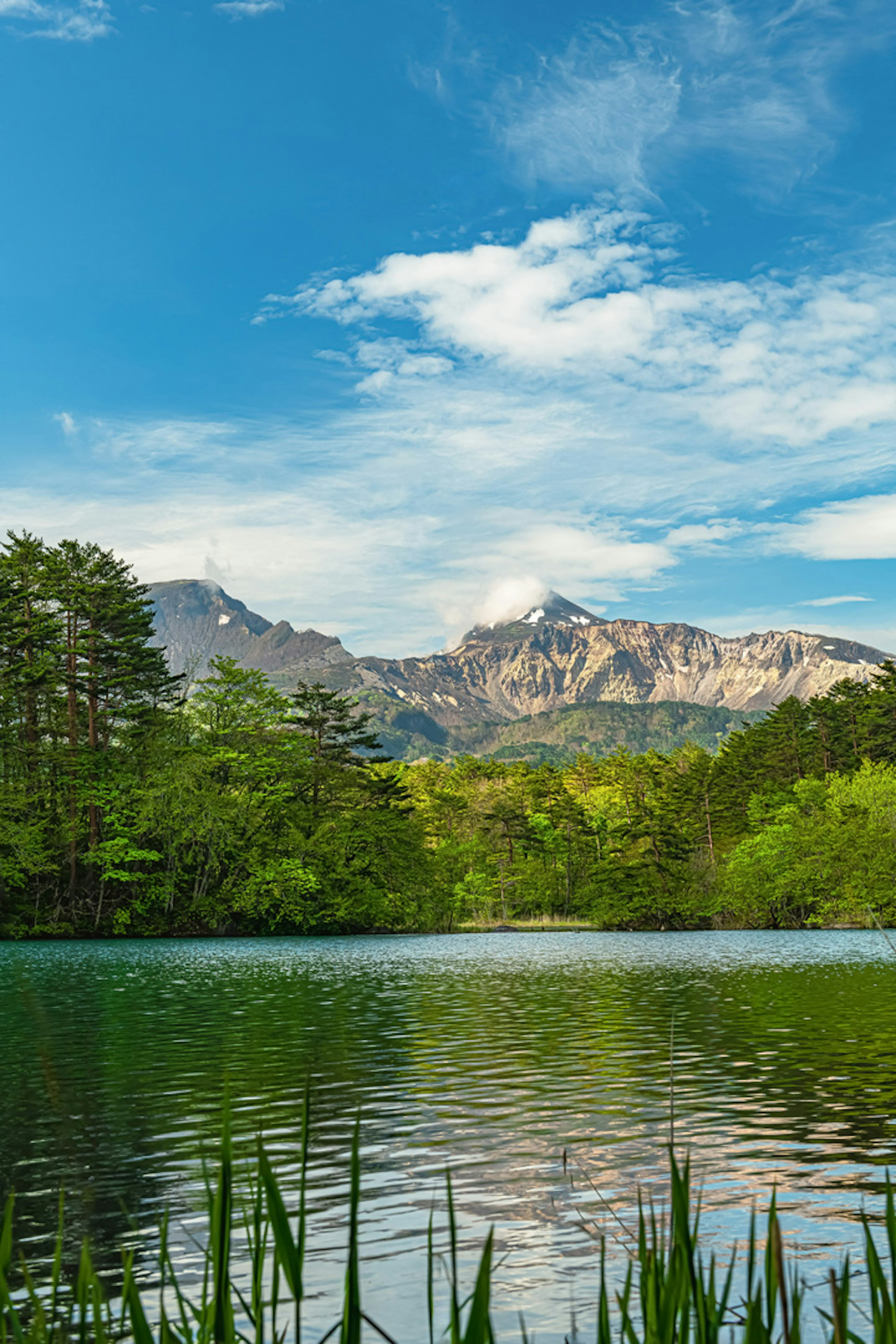 Serene lake landscape reflecting blue sky and mountains