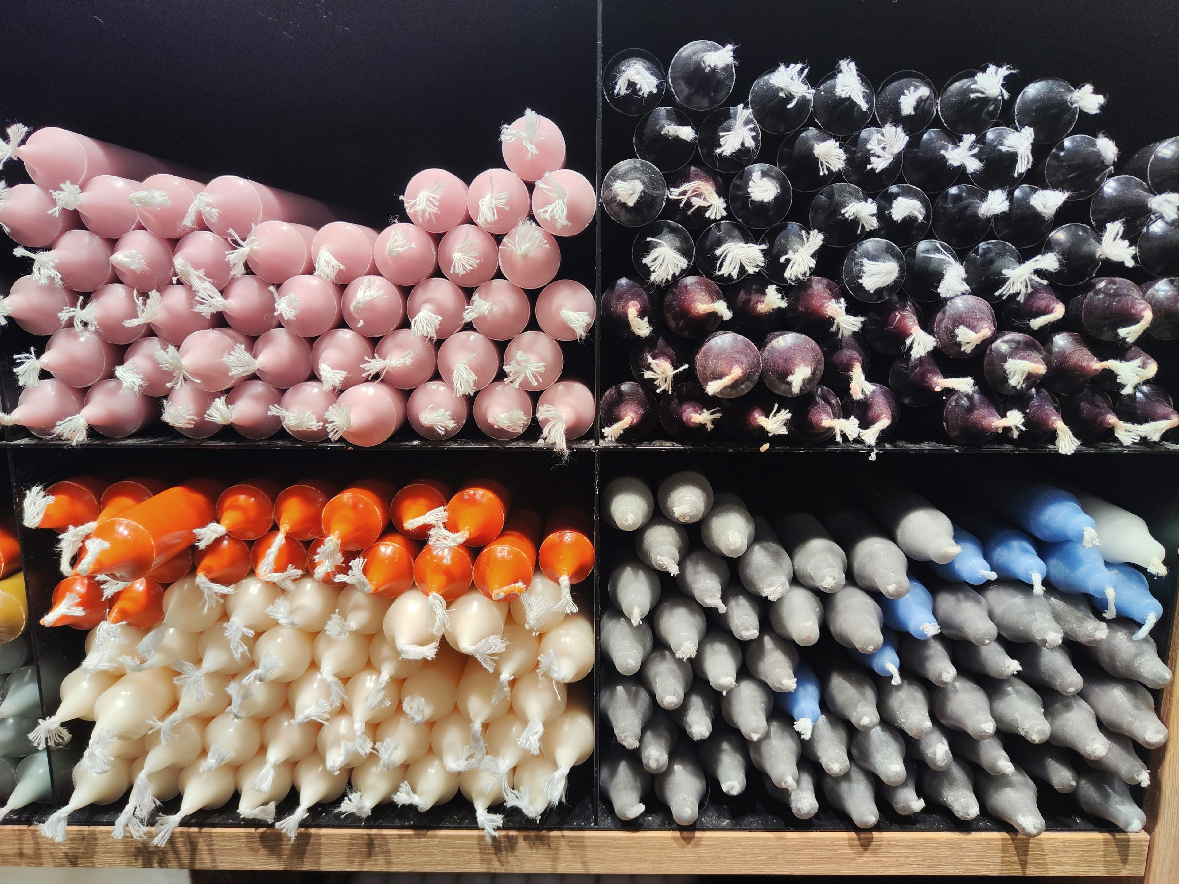 Shelves filled with colorful candles in various shapes