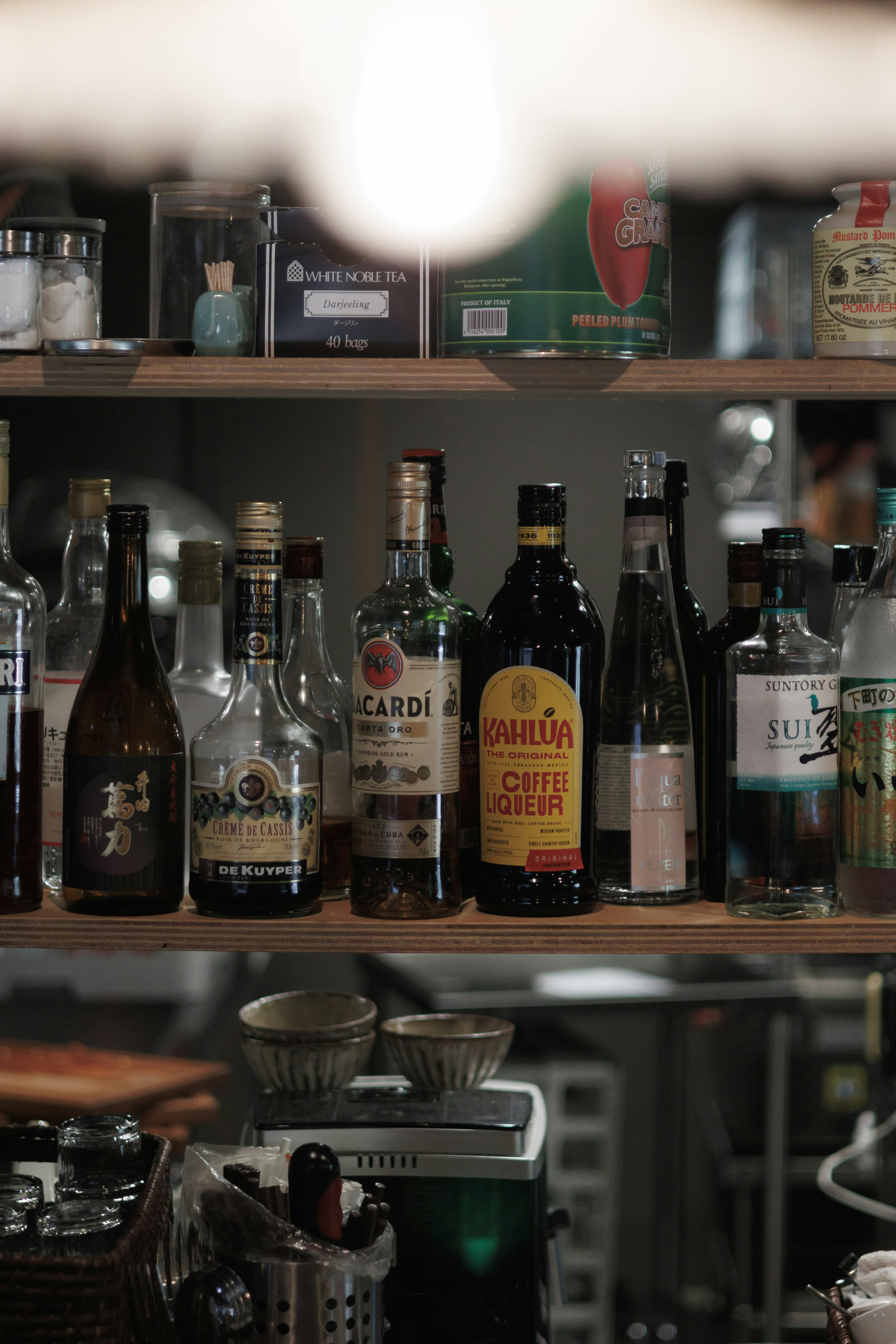 A shelf displaying various bottles of liquor and condiments