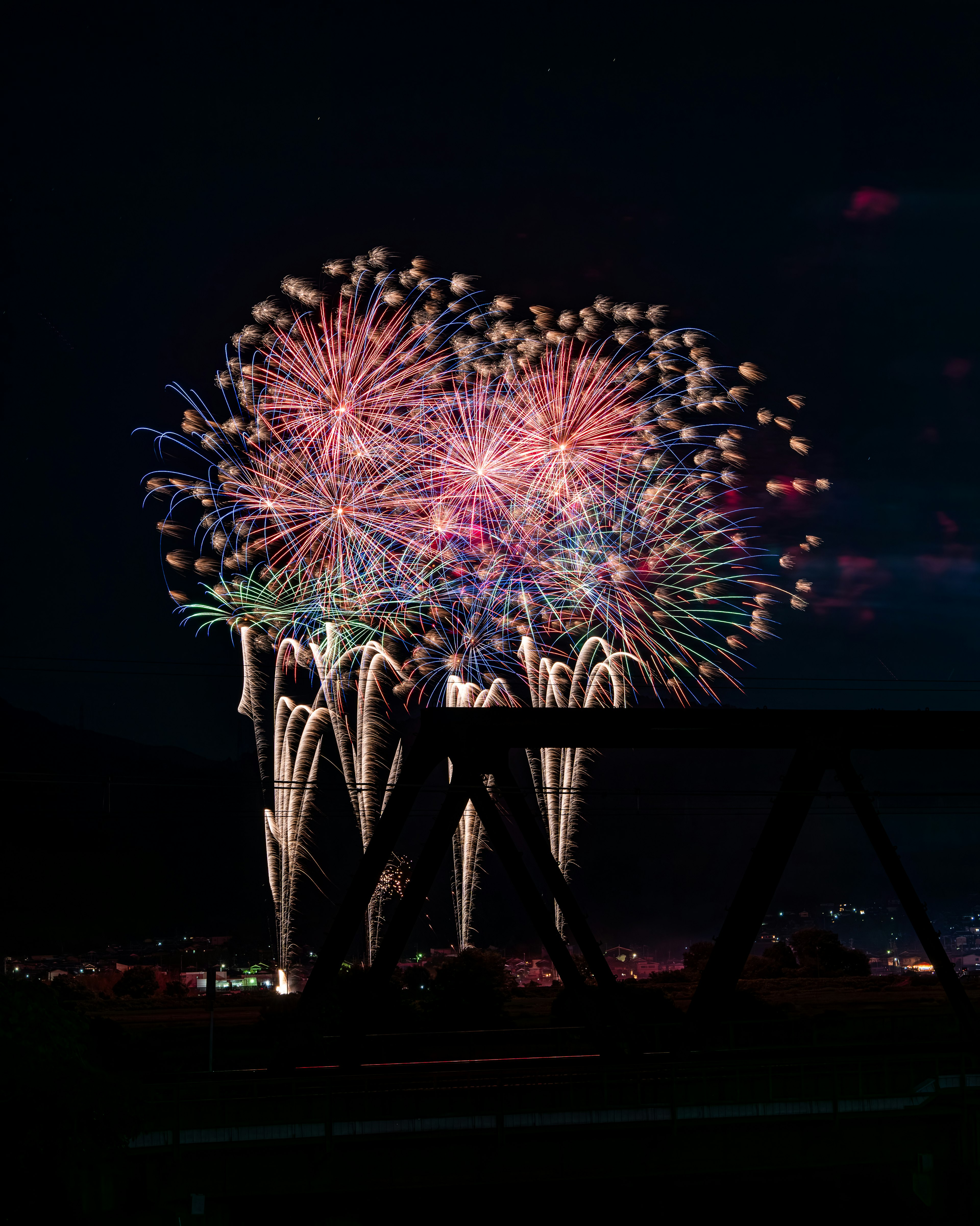 Fuochi d'artificio colorati che illuminano il cielo notturno con una struttura in primo piano