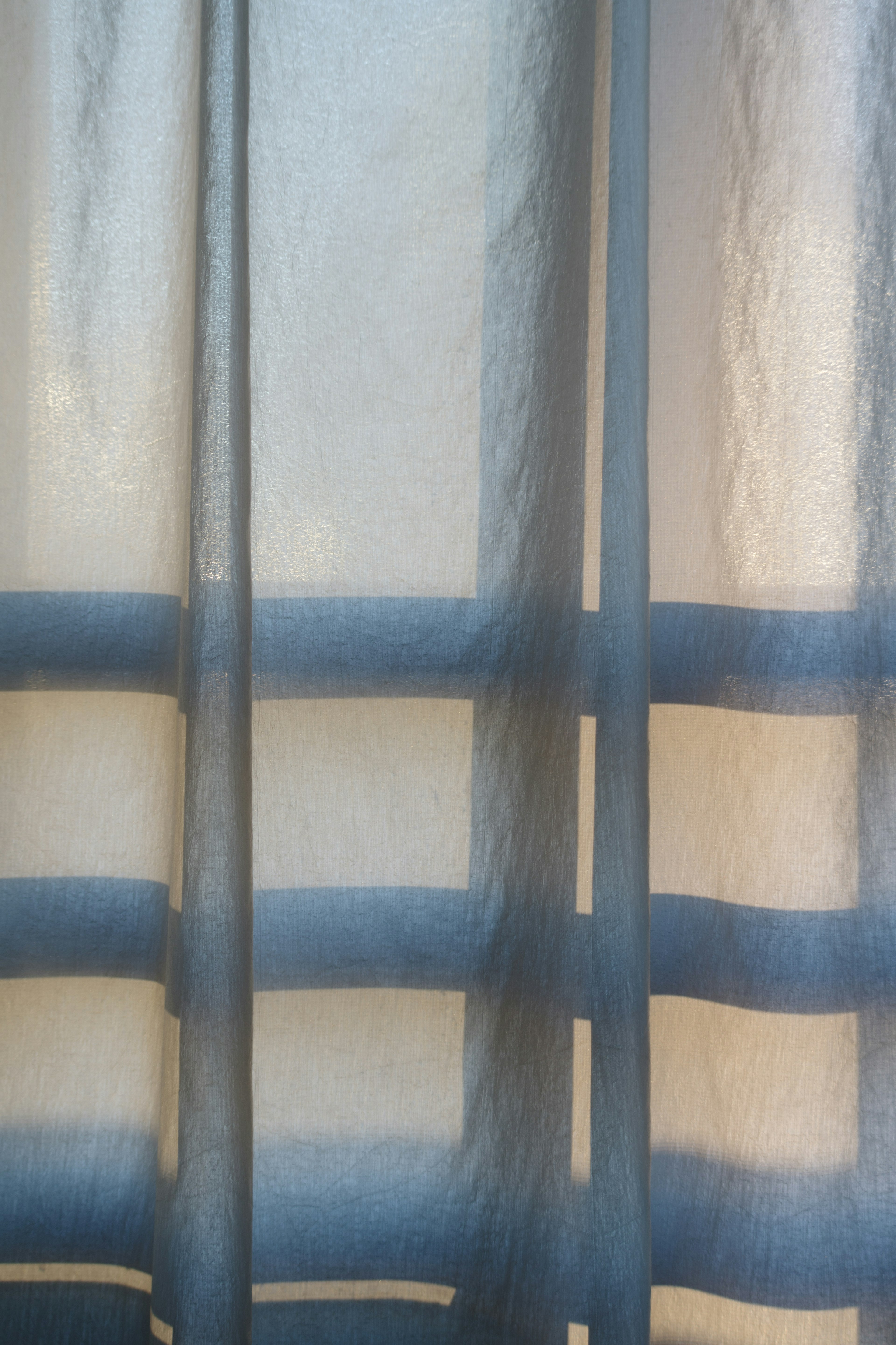 Blue striped curtain with light filtering through