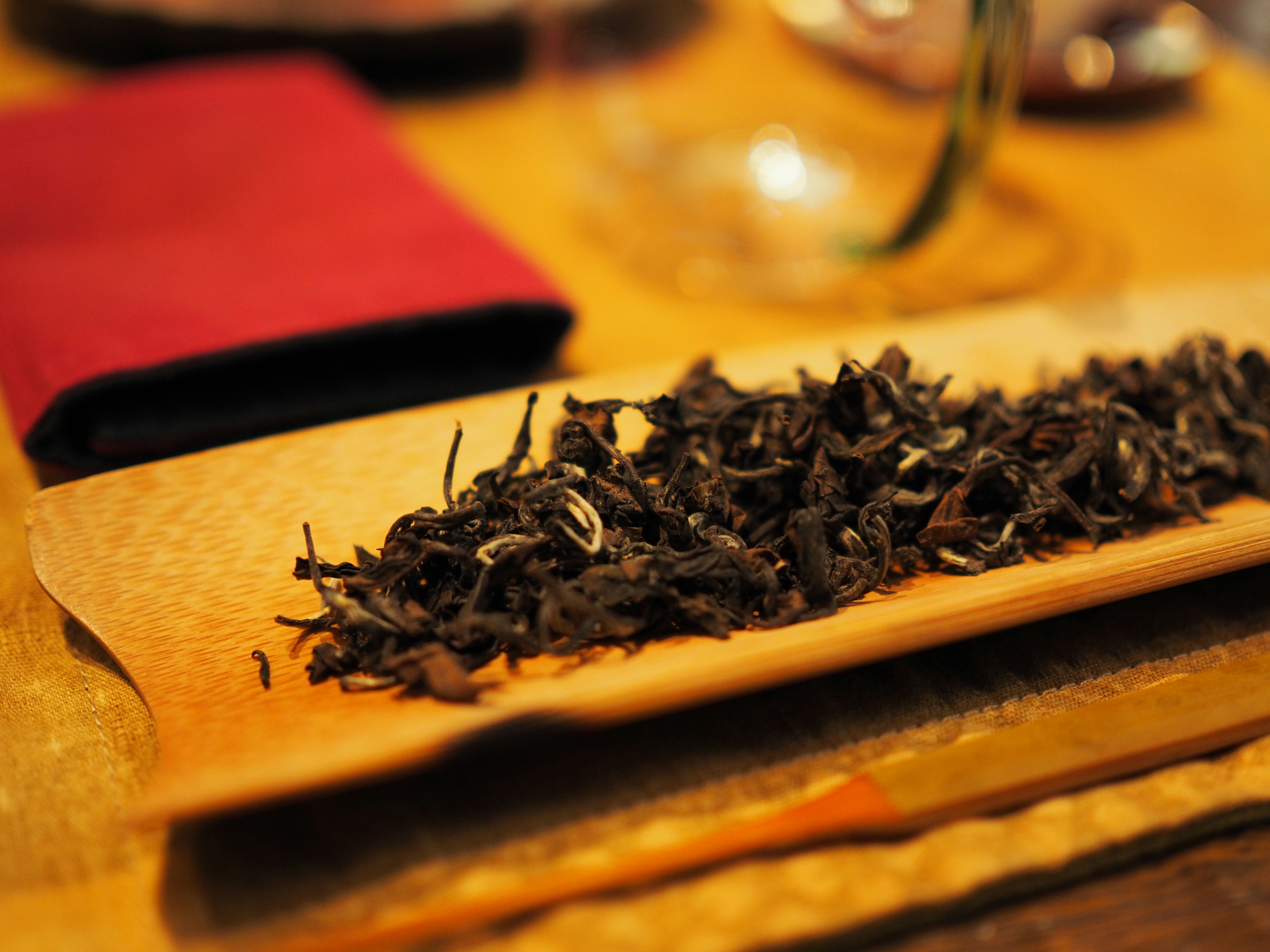 Close-up of dried tea leaves on a wooden plate