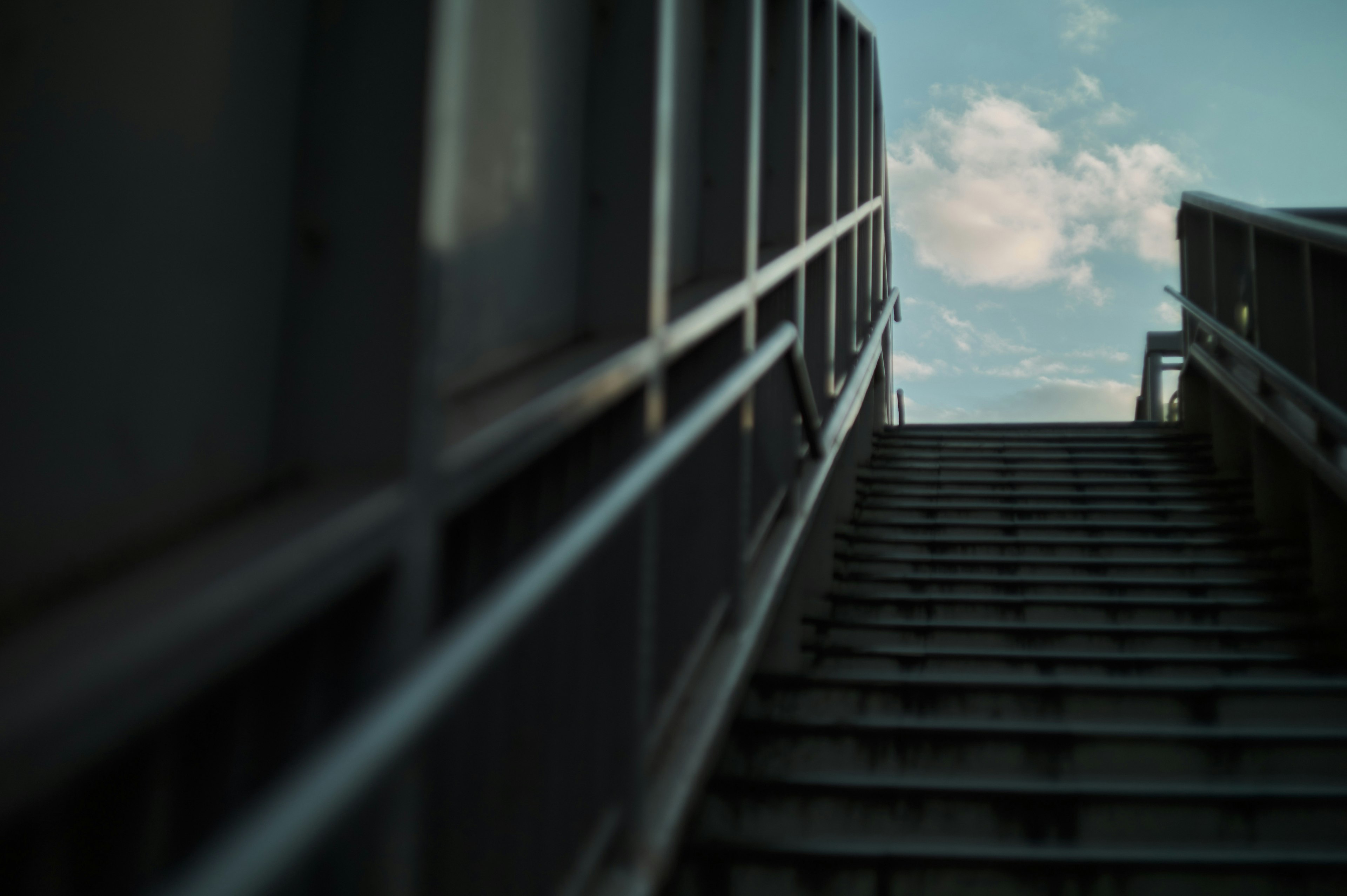 Foto de escaleras desde un ángulo bajo mostrando cielo azul y nubes