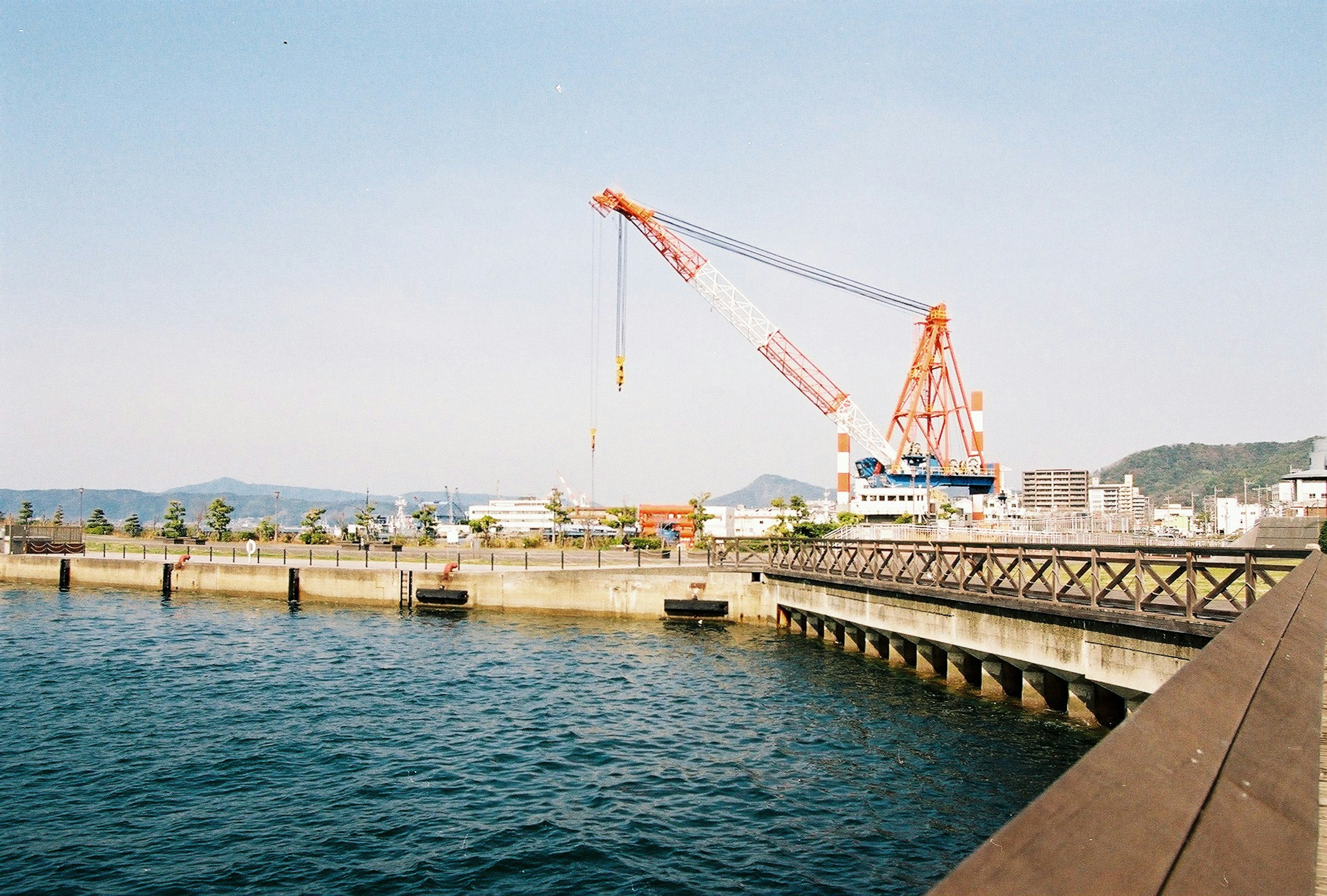 ทิวทัศน์ท่าเรือที่มีเครนและน้ำสงบ