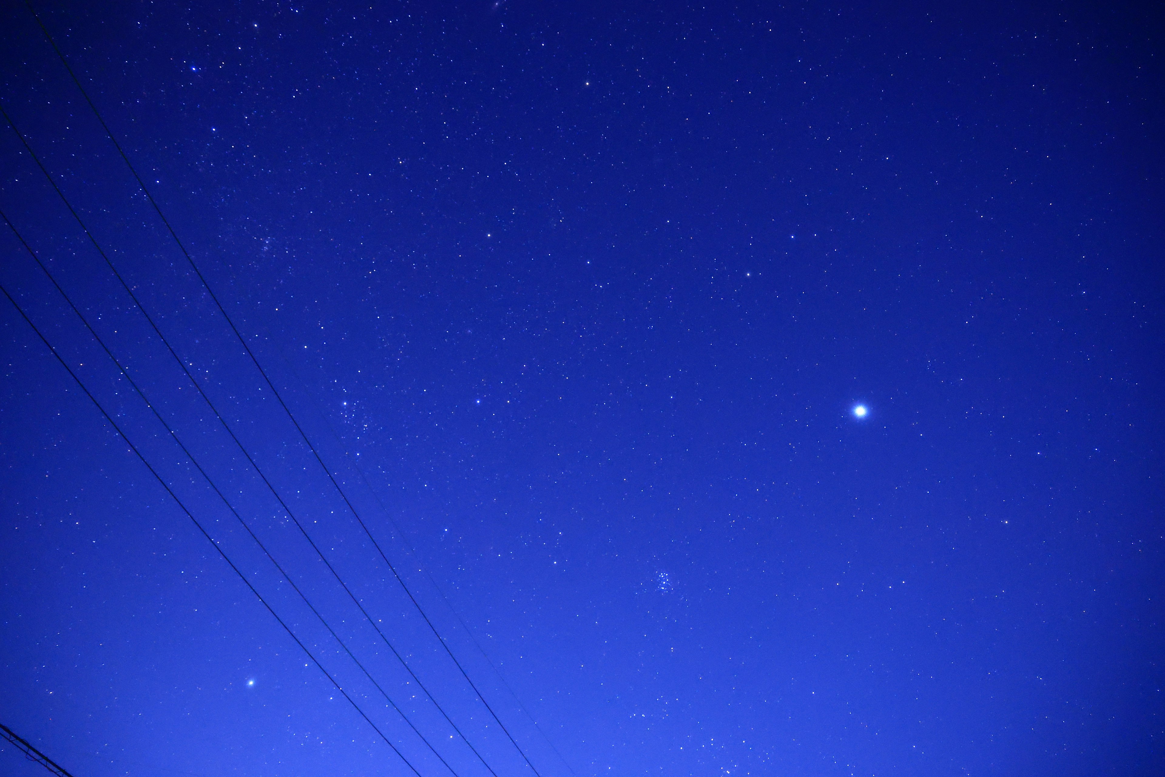 Cielo notturno stellato con stelle luminose e linee elettriche