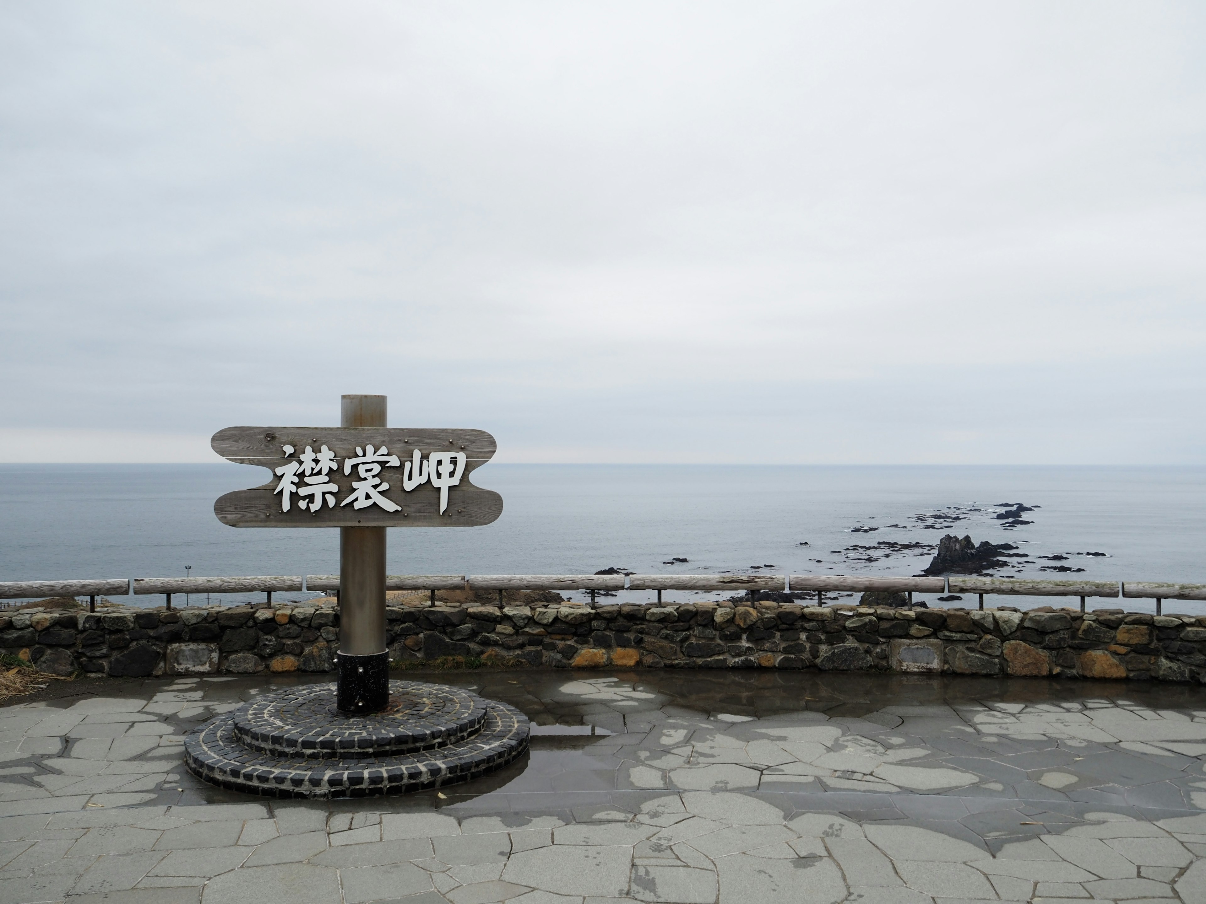 A signpost with Japanese characters overlooking the ocean