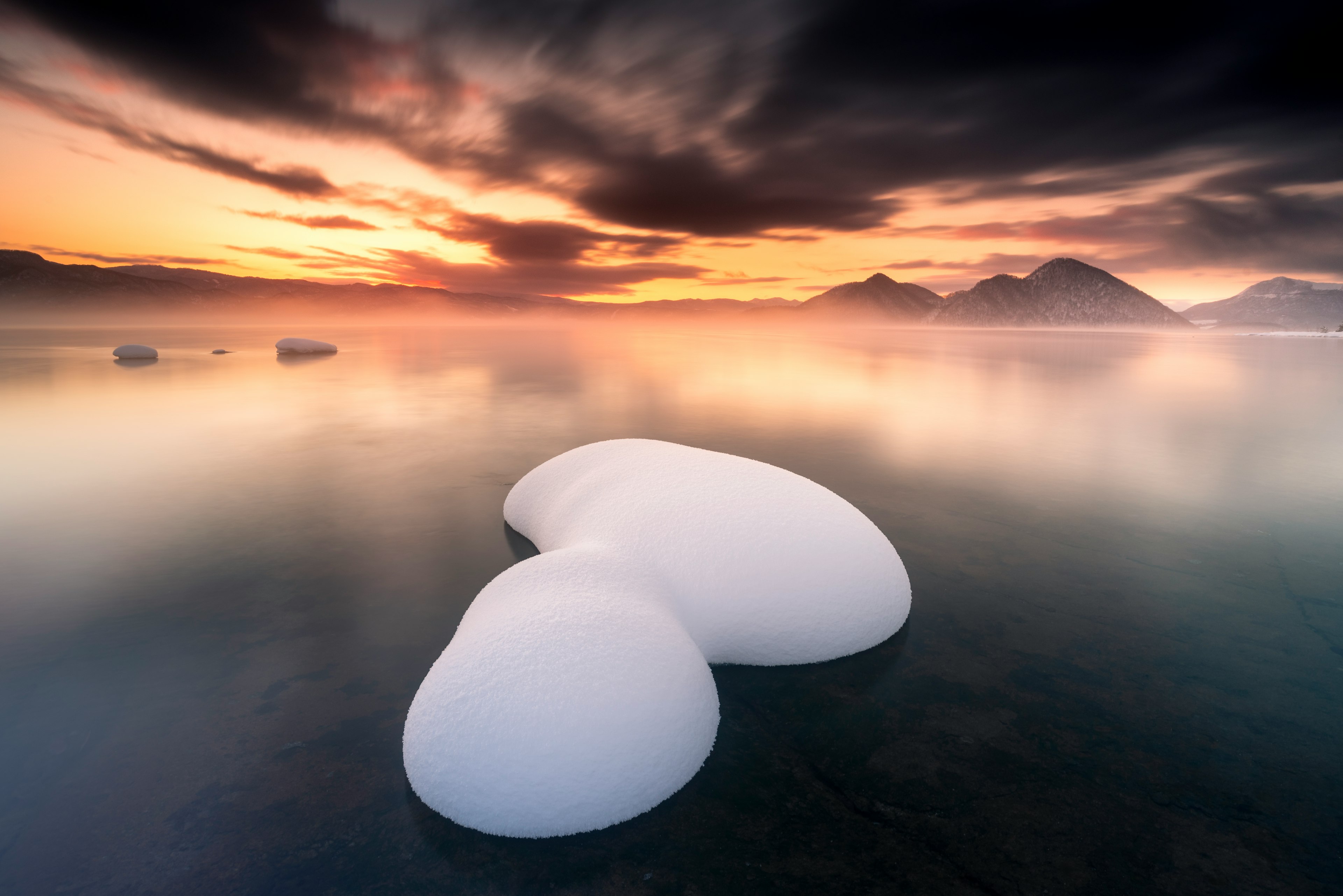 Formazioni di ghiaccio bianche su un lago tranquillo con un bellissimo tramonto