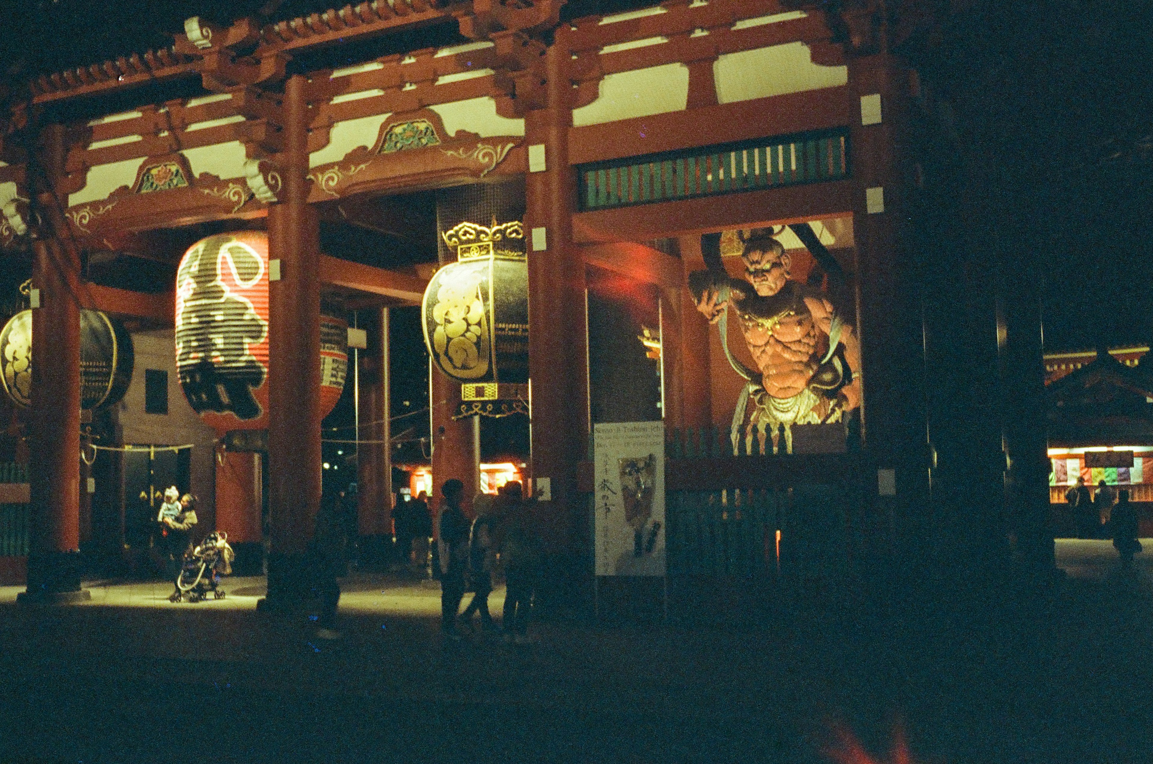 Night view of Senso-ji Temple with large lanterns and a giant mural