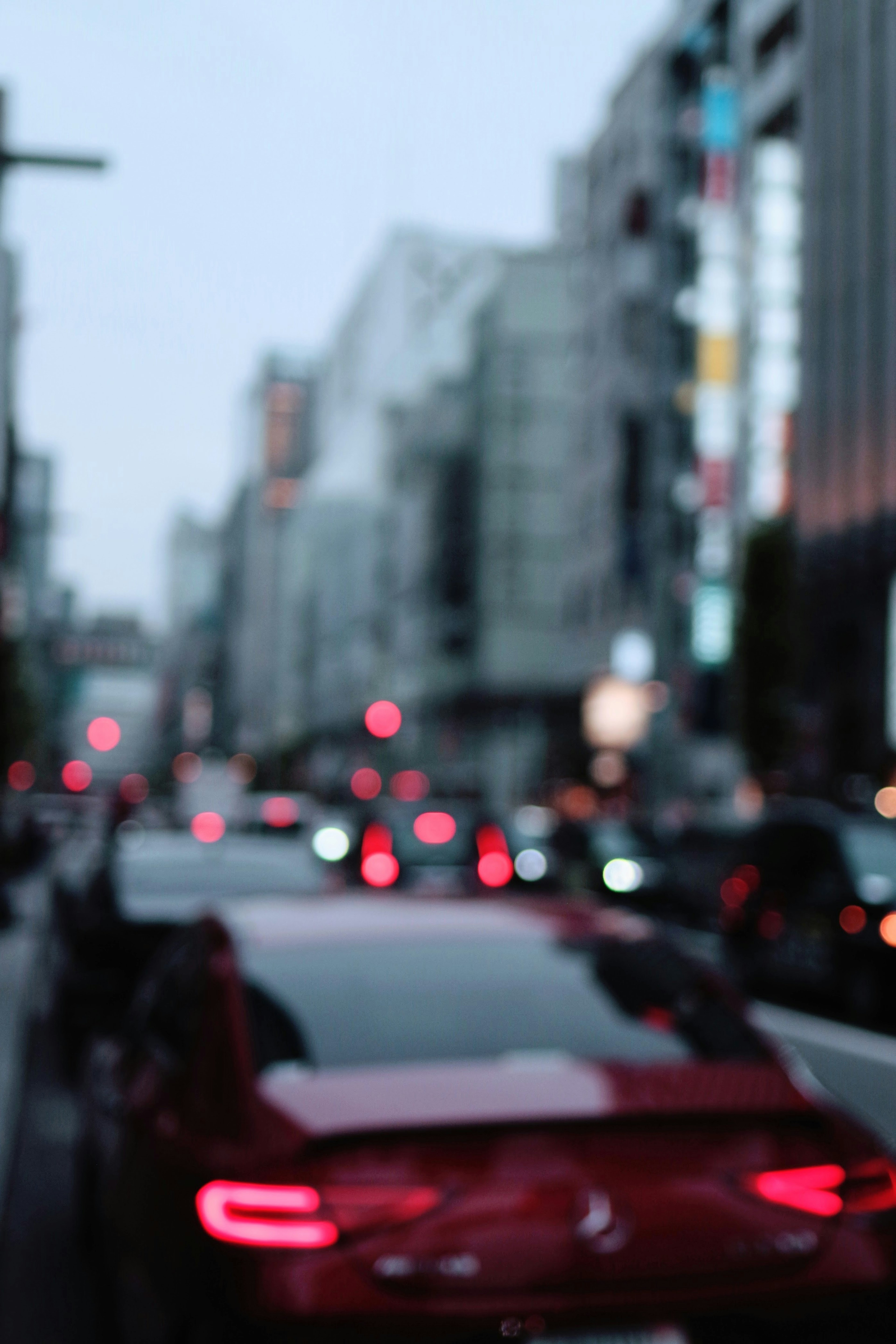 Paysage urbain flou avec une voiture rouge et des lampadaires lumineux