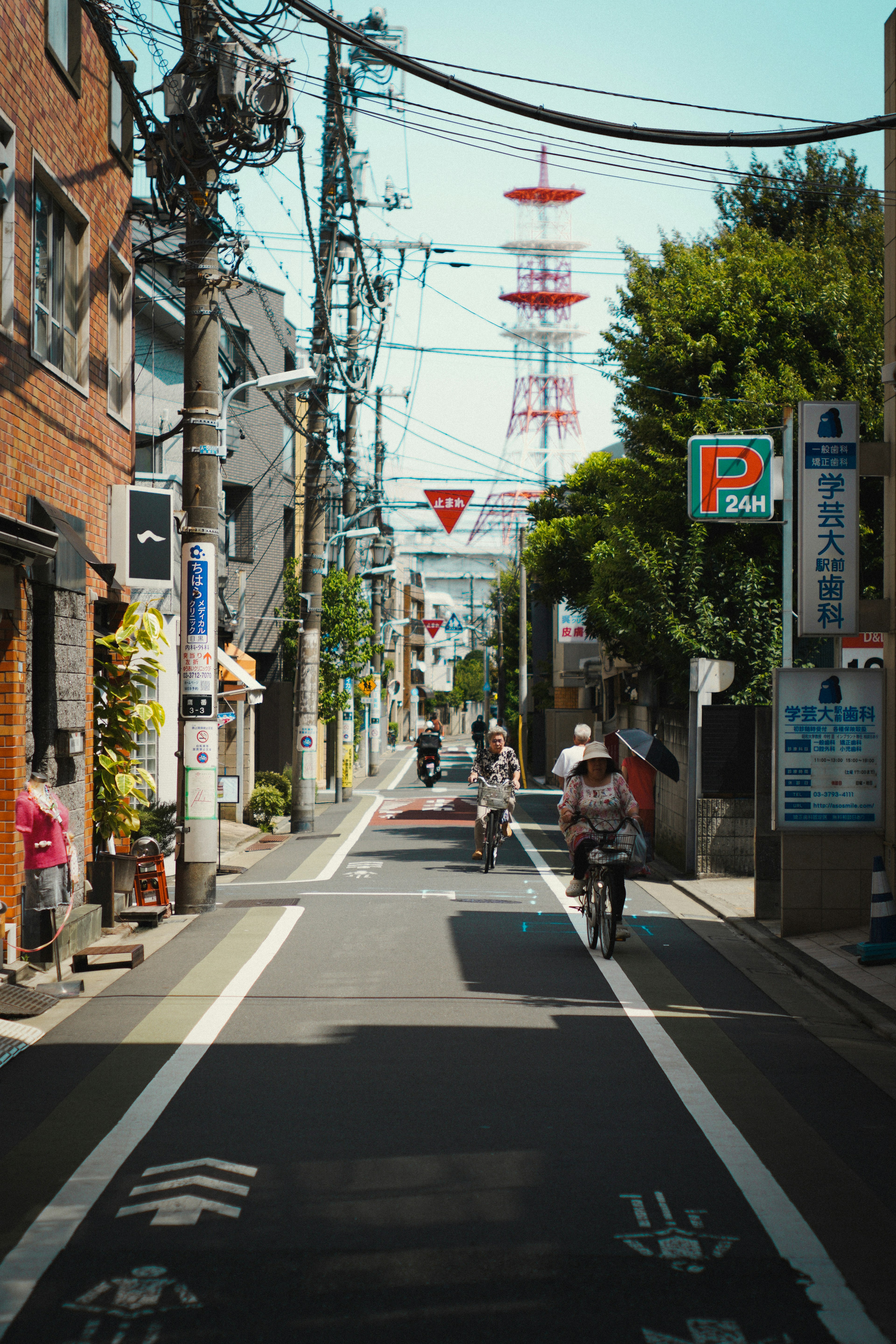 Bicicletas en una calle de Tokio con una torre roja al fondo