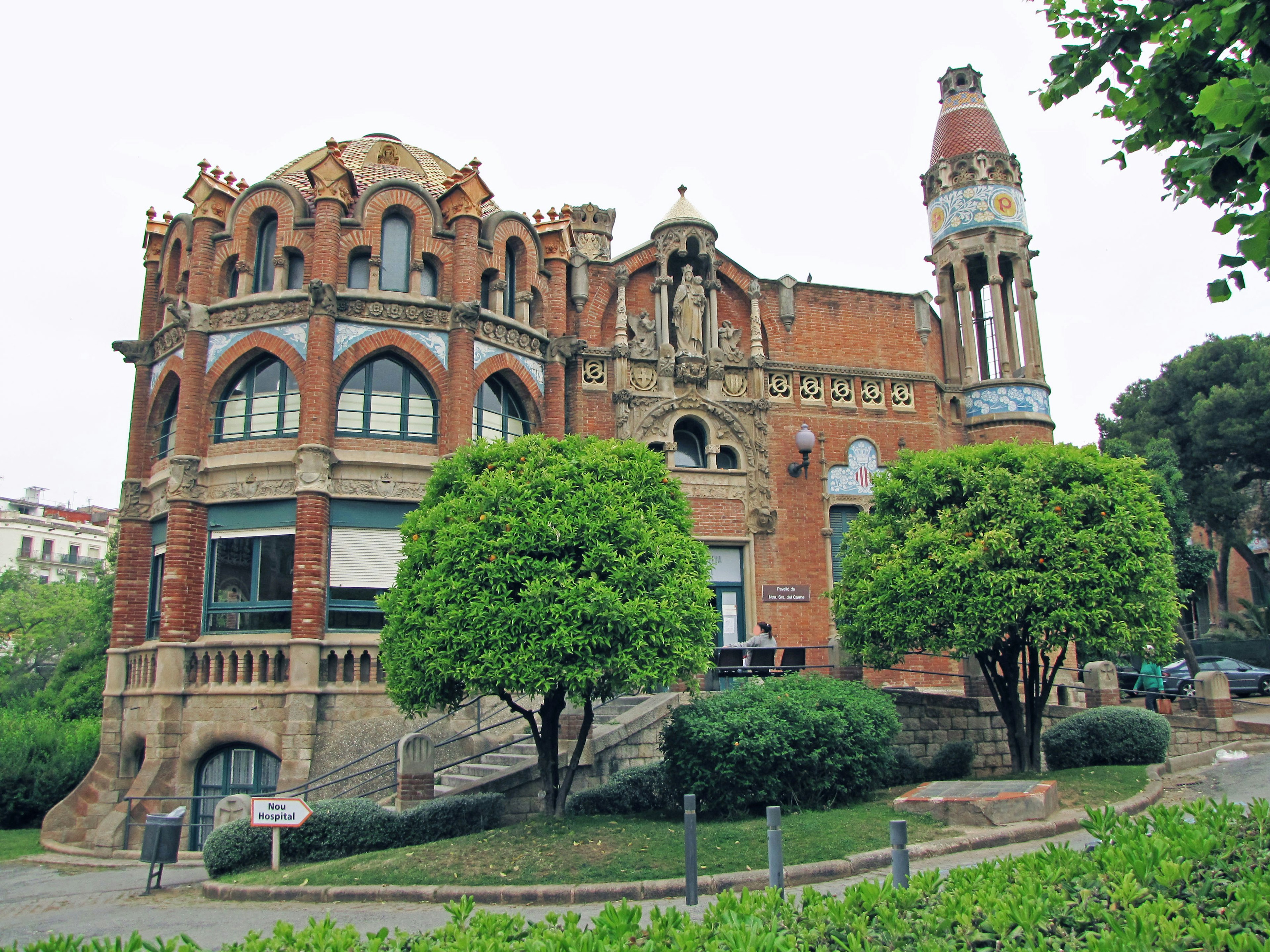 Ornate red brick building surrounded by green trees historic architecture