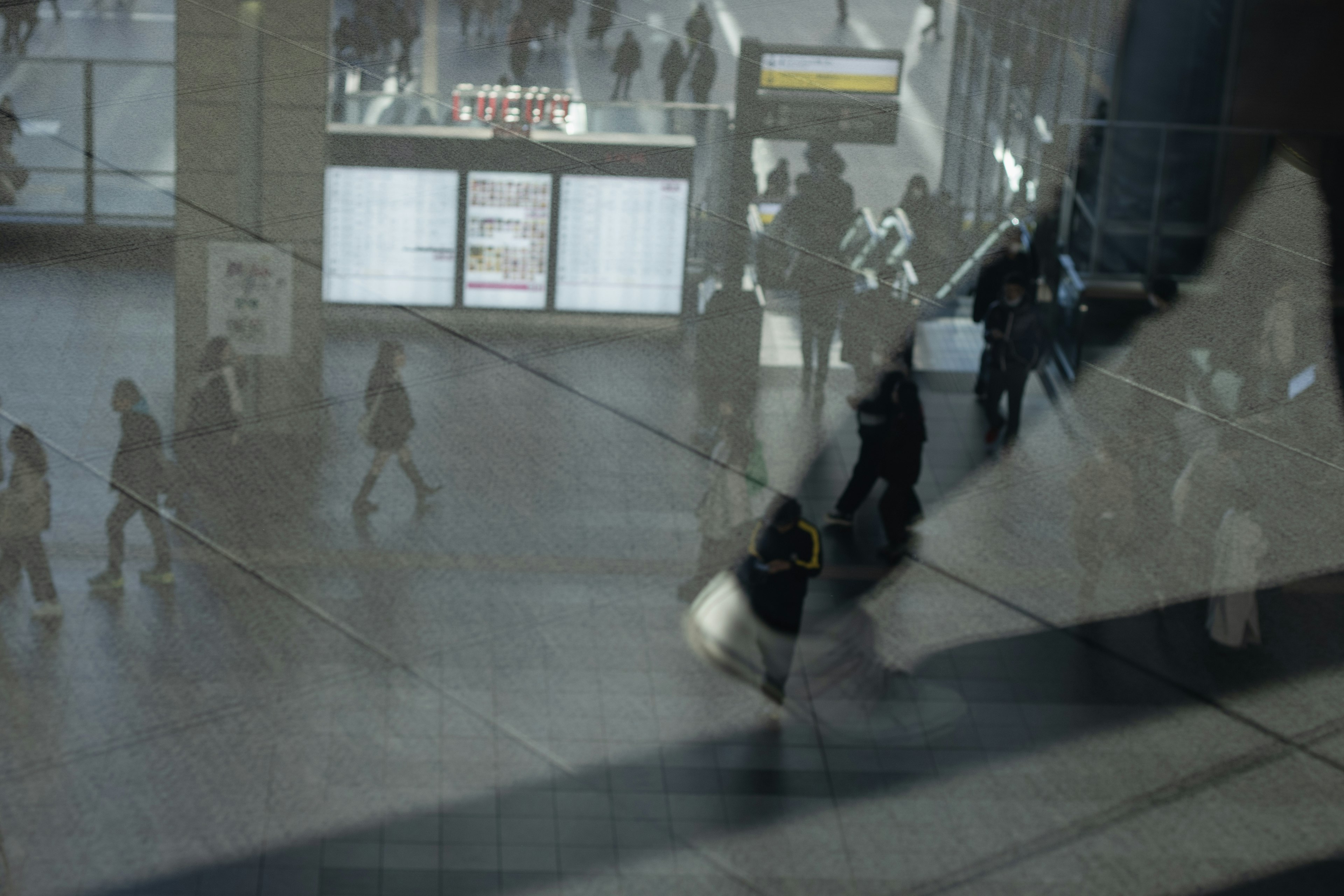 Scène d'un hall de gare animé avec des personnes en mouvement à travers du verre transparent