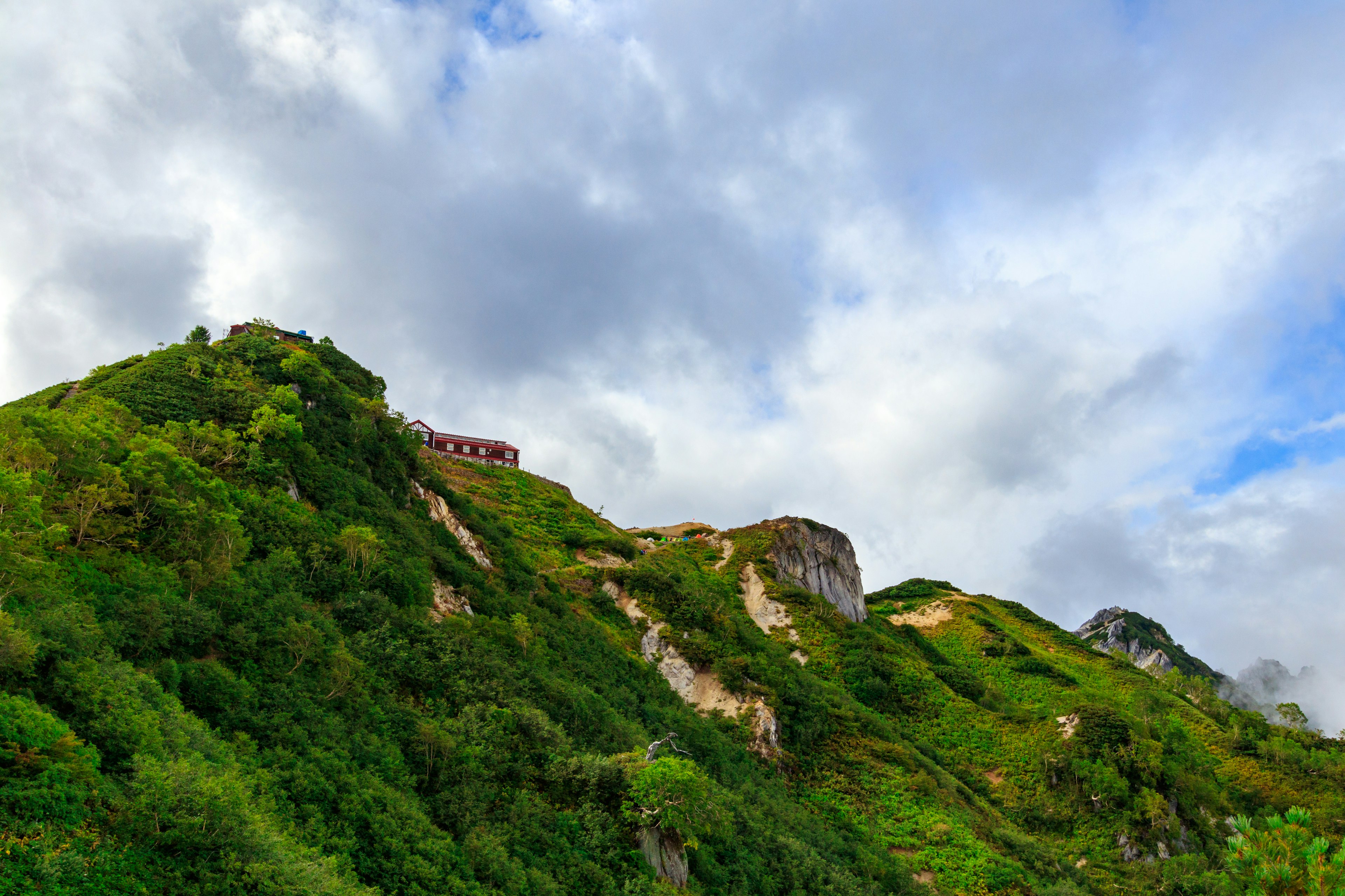 Collina verde lussureggiante con cielo nuvoloso