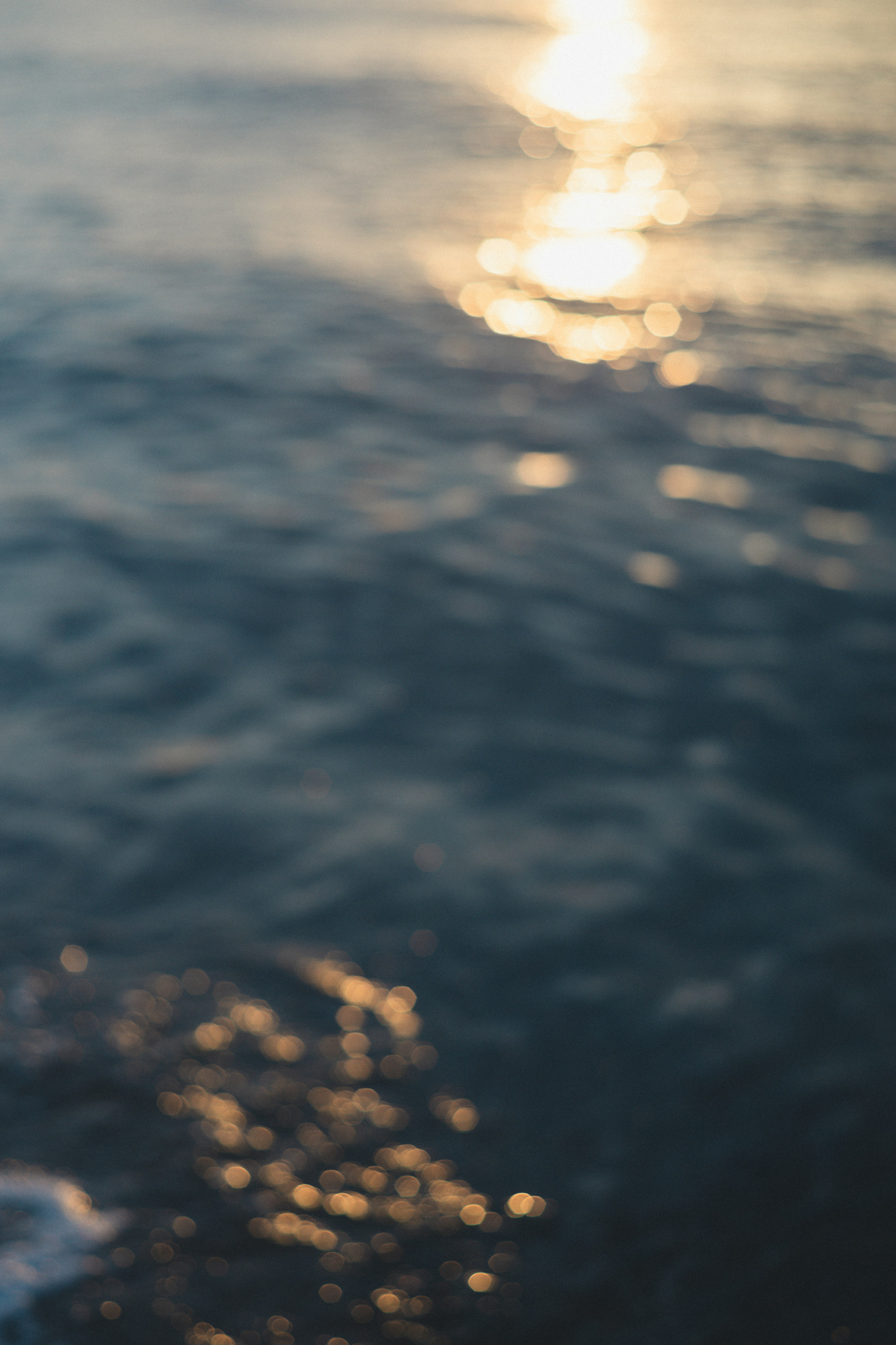 ぼやけた海の水面に反射する太陽の光