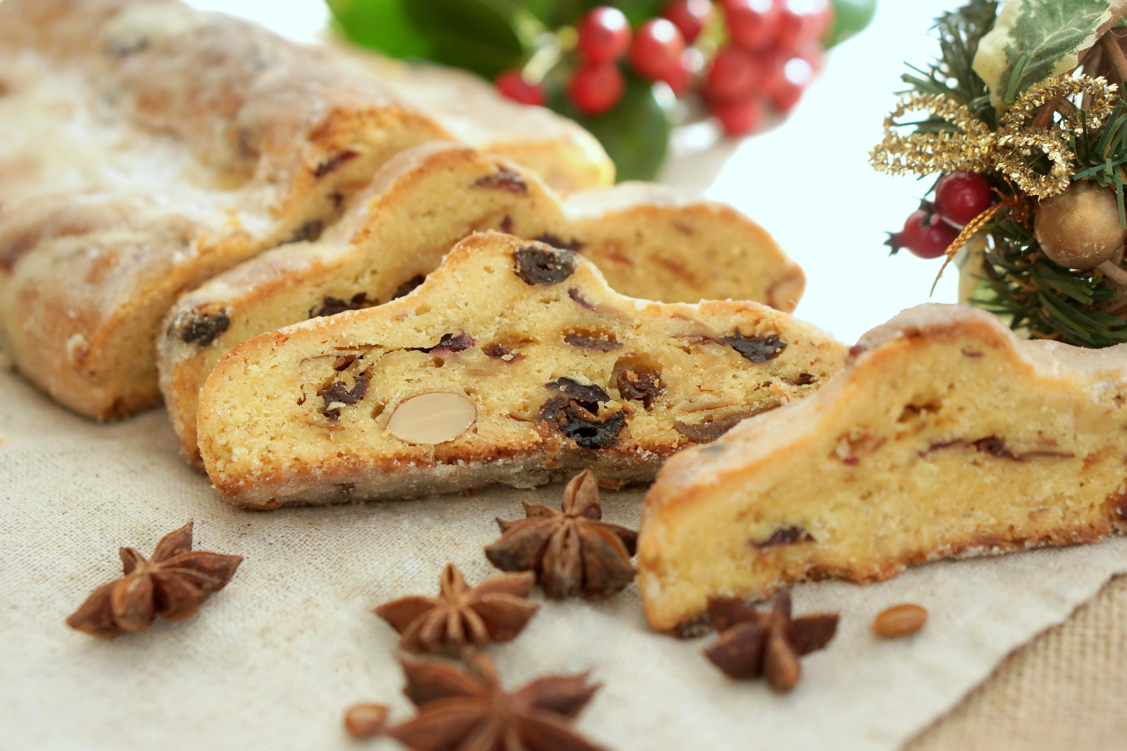 Sliced Christmas cake placed on a festive table with decorations and star anise