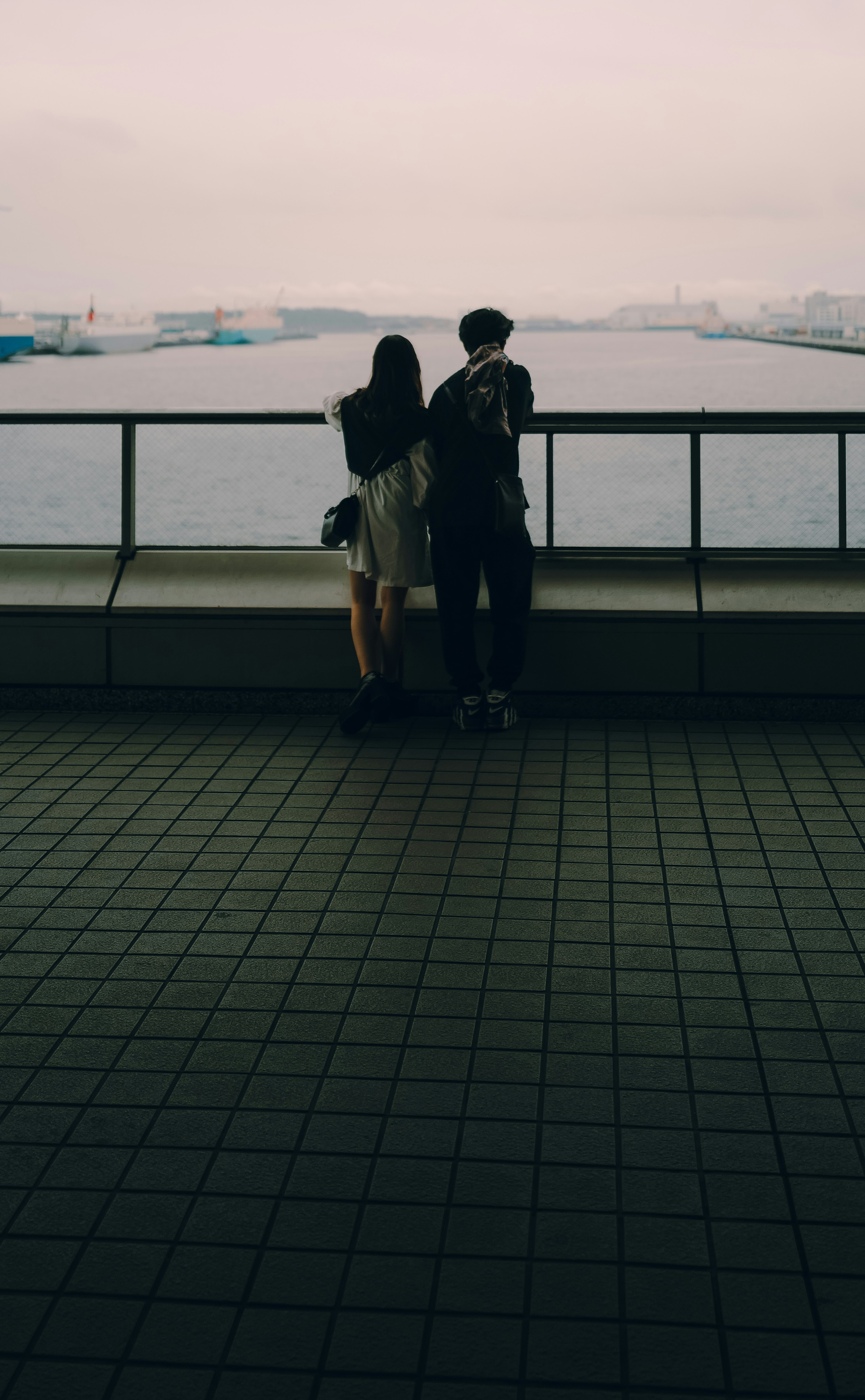 Couple gazing at the sea with a cloudy sky and water in the background