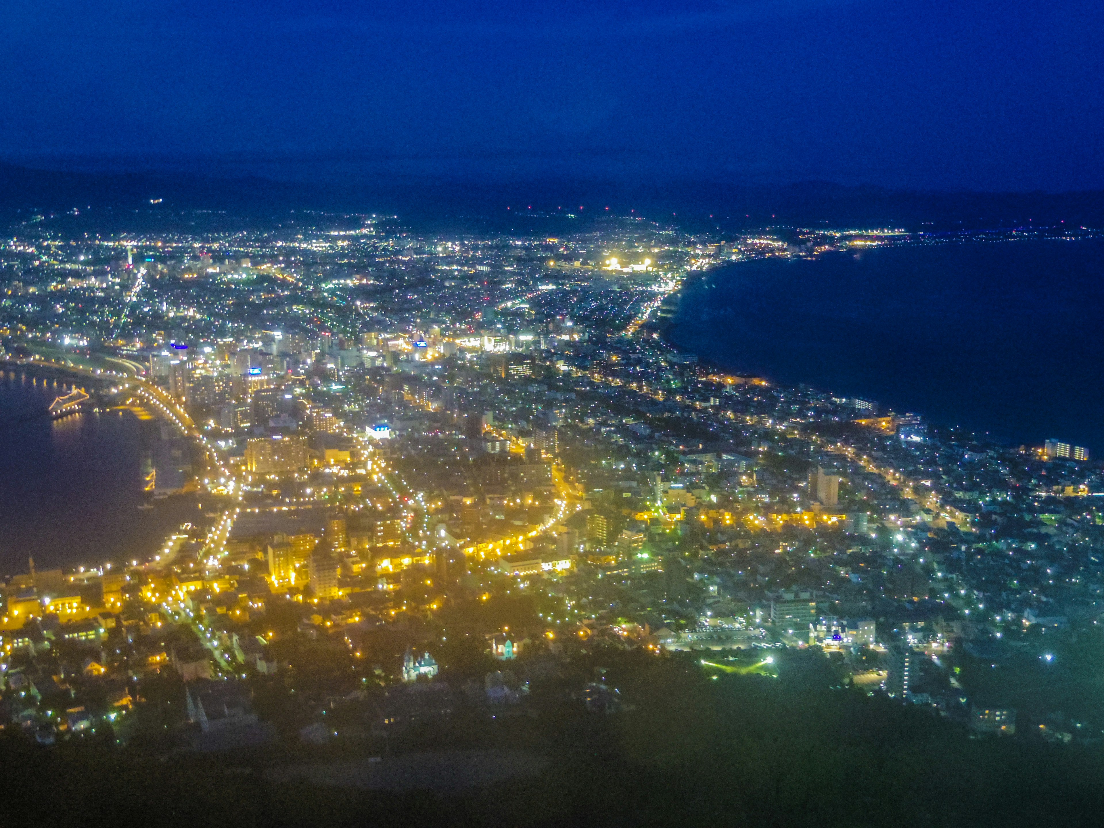 Vue nocturne magnifique d'une ville avec des lumières brillantes éparpillées